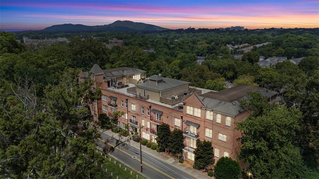 This elegant four-sided brick building makes a striking first impression with its classic design and enduring character. Within the residence, the sophistication continues as you are immediately greeted by the timeless elegance of grand columns that define the dining room as its own sophisticated space. Gleaming hardwood floors, soaring 10-foot ceilings, and an abundance of natural light set the tone for an open and airy floorplan. The great room is both stylish and inviting, enhanced by recessed lighting, custom built-in bookshelves, and a cozy fireplace perfect for relaxing on winter nights. Through French doors, the private patio offers a quiet retreat for morning coffee or evening unwinding.
The gourmet kitchen is a chef’s dream, boasting Bosch stainless steel appliances, granite countertops, and endless cabinetry. Thoughtfully designed to overlook the great room, it is ideal for both entertaining and everyday living. This is not your typical condo, featuring three bedrooms and three bathrooms, including two primary suites, the home offers remarkable flexibility. Whether you need space for a teen suite, an in-law retreat, or a private office on the opposite side of your bedroom, the possibilities are endless. Both primary bathrooms feature double vanities, while the main suite elevates the experience with a stand-up shower, soaking tub, and dual closets designed for those who love to shop or simply love their own space. Adding to the charm, a Juliet balcony allows you to open the doors to crisp fall air and the sounds of the season.
Peace of mind comes easily here, as the HOA covers nearly everything. Exterior maintenance, gas, water, insurance, termite protection, pest control, and trash are all included, allowing you to simply turn on the power and relax. The condo also provides ample visitor parking, a deeded parking spot, and a private storage unit with electrical. For seamless convenience, the elevator carries you directly from the parking garage to your condo and up to the rooftop observatory, where panoramic views provide both tranquility and the perfect backdrop for entertaining.
This residence is located just steps from the vibrant Marietta Square, where you can enjoy year-round festivals, concerts, restaurants, art shows, fireworks, and seasonal celebrations for all to enjoy. Outdoor enthusiasts will also appreciate being just minutes from Kennesaw Mountain, offering endless opportunities to hike, bike, or enjoy a leisurely stroll surrounded by nature. With quick access to I-75, only 15 minutes from Truist Park and The Battery, and a boutique community of just 18 units, this home offers the perfect balance of charm, convenience, and exclusivity. Opportunities like this are rare, and finding a home of this caliber, in this location, at this price, is truly extraordinary. All that's missing is you!