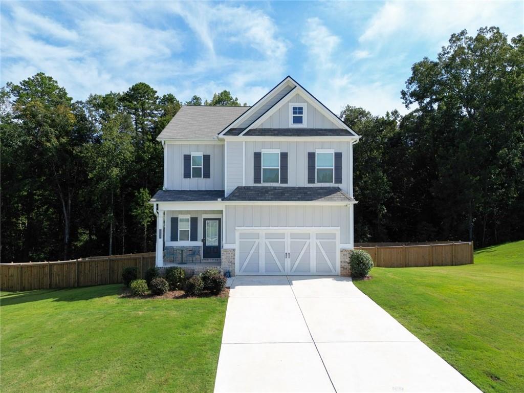 Wake up to sunlight pouring through large, picturesque windows and savor your morning coffee on the deck overlooking your fenced backyard and half-acre lot, with plenty of space between you and the next home. This Cynthia floor plan in Laurel Cove, just minutes from the new Jackson County High School, is designed for living, entertaining, and making memories. The main level flows effortlessly with wide Luxury Vinyl Plank flooring and a kitchen that’s both beautiful and functional, featuring white cabinetry, a large island, herringbone backsplash, and stainless steel appliances. A guest bathroom adds convenience, while the full daylight basement, already stubbed for a bath, is ready for a home gym, media room, or play space. Upstairs, the primary suite is a peaceful retreat with a tray ceiling, walk-in closet, and spa-style bath with soaking tub and separate shower. Three additional bedrooms, including one with its own bath, an office nook, and laundry complete the upper level, giving space for family, guests, and everyday life. From quiet mornings on the deck to lively dinners in the kitchen, this home combines space, style, and warmth in every corner.