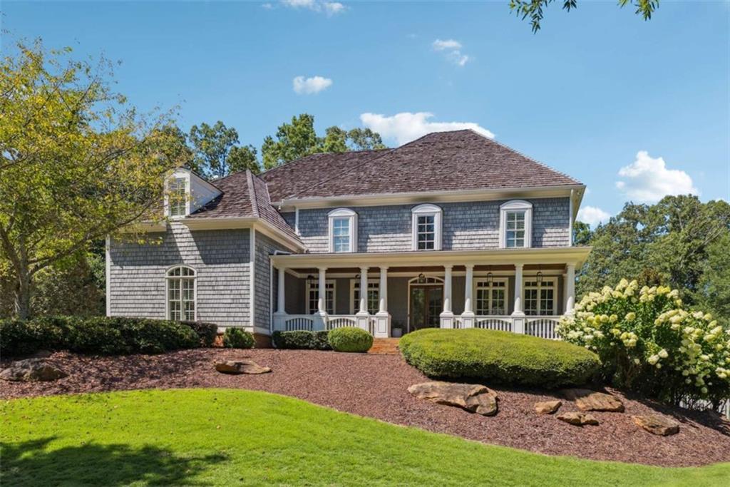 Originally crafted by renowned builder Steve Powell, this timeless Cape Cod-style residence is set within one of Milton's most prestigious and intimate neighborhoods-just 10 minutes from Downtown Crabapple, Alpharetta, and GA-400-offering an exceptional blend of elegance, privacy, and convenience.. Beautifully reimagined with a professionally designed remodel, the home features white oak floors with a soft white country stain throughout, curated lighting, designer wallpaper, and soft arch doorways that lend an air of quiet sophistication. The sun-drenched interiors boast lush green views from every room, inviting the outdoors in and creating a serene, natural backdrop throughout. The heart of the home is a chef's kitchen featuring Mykonos quartzite countertops, high-end appliances, and a fully custom butler's pantry-all with direct sightlines to the backyard and pool area from the kitchen, main floor, and much of the second level. A new roof, fully replaced just 4 years ago, adds lasting peace of mind. The spacious primary suite offers a serene retreat, while the finished walkout basement with stained concrete floors provides endless possibilities for recreation or relaxation. Thoughtful features like a newly updated mudroom, two laundry rooms, and a fully integrated alarm system make everyday living effortless. Outside, discover your own private oasis: a new heated saltwater pool and spa wrapped in full-color bluestone, a covered porch with outdoor fireplace, and a dedicated space plumbed for your dream outdoor kitchen. Two walkout-accessible yards-a backyard and a side yard-provide ample space for entertaining, play, or gardening, supported by a new full-yard irrigation system. With a 4-car garage, stunning design, and zoning for Milton's top-ranked schools, this home offers the rare combination of timeless craftsmanship and modern comfort. Cape Cod charm meets refined modern living-welcome to Crabapple Estates.