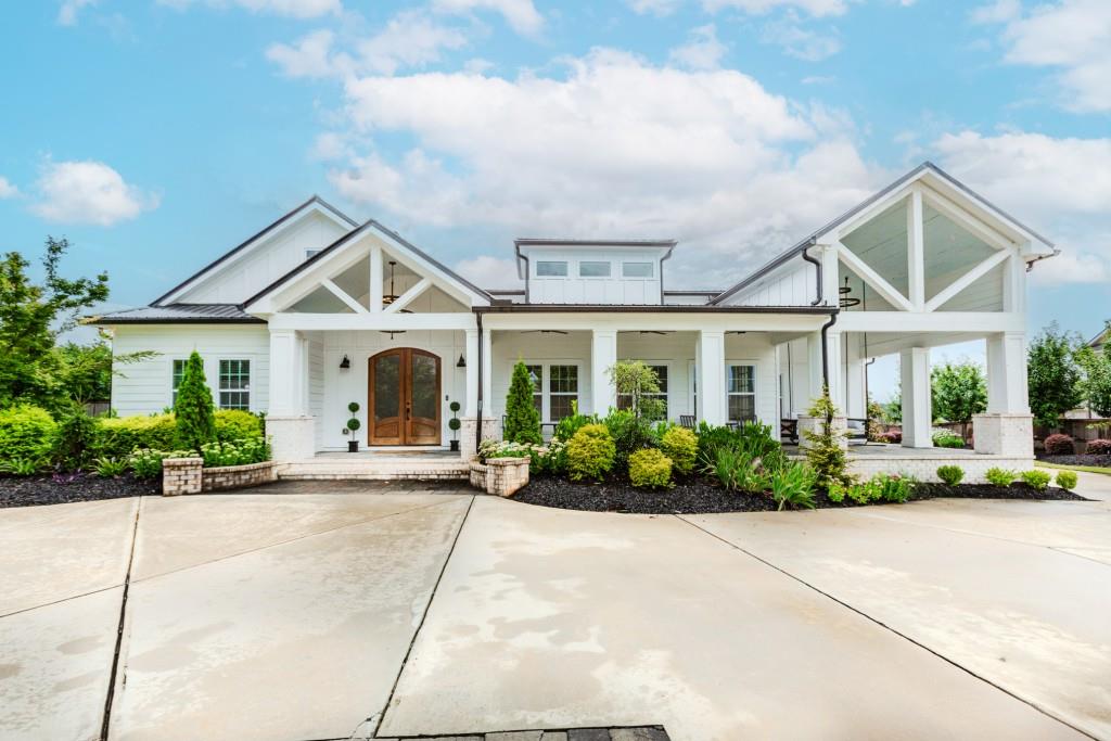 One-of-a-Kind Historic Meets Modern Luxury in City of Buford Schools. If you're dreaming of living in Hall County and going to the City of Buford Schools, the top school in the nation and want a home like no other, this is the one you been waiting for. As you pull into this one-of-a-kind, fully fenced property through the electric privacy gate, you're immediately welcomed by unmatched charm and character. Originally built in 1935 and thoughtfully expanded in 2023, this exceptional property blends timeless southern charm with modern luxury and custom craftsmanship. Step through the double doors into a grand open foyer. To the left, discover a cozy bedroom featuring original wood walls, exuding rustic charm. To the right, a spacious family room welcomes you with a fireplace, abundant natural light, striking accent walls and ceilings, skylights, and another set of double doors opening onto a serene front porch complete with a swing. The gourmet kitchen is a showstopper, overlooking the family room and featuring three fireplaces, a large center island, a 5-burner gas cooktop, double wall ovens, granite countertops, and crisp white cabinetry. The primary suite is truly one of a kind. Enormous in size, it features a cozy sitting area, its own fireplace, a dramatic glass roll-up garage door leading to a private outdoor oasis, soaring vaulted ceilings, and two oversized walk-in closets, one with washer/dryer hookups. The luxurious master bath offers a spa-like retreat with free-standing soaking tub, double vanity, and a massive walk-in shower with dual shower heads and three spray heads on the wall. The main floor also includes another additional spacious bedroom, 2 full baths with walk-in showers, and a dedicated laundry room. Upstairs, you'll find a versatile loft/office area, plus two more generously sized bedrooms, each with their own full bath and large walk-in closets. Outside, the backyard is an entertainer's dream. Enjoy the heated saltwater pool with sun lounge and hot tub, a relaxing cabana with TV, and a converted barn full of character and endless possibilities, perfect for hosting or creating a personal retreat. The professional landscaping is enhanced by outdoor lighting throughout, creating a stunning ambiance for evening enjoyment. For car enthusiasts or hobbyists, the detached garage/workshop includes two four-post car lifts. The beautifully manicured landscaping and courtyard-style driveway complete this extraordinary property.