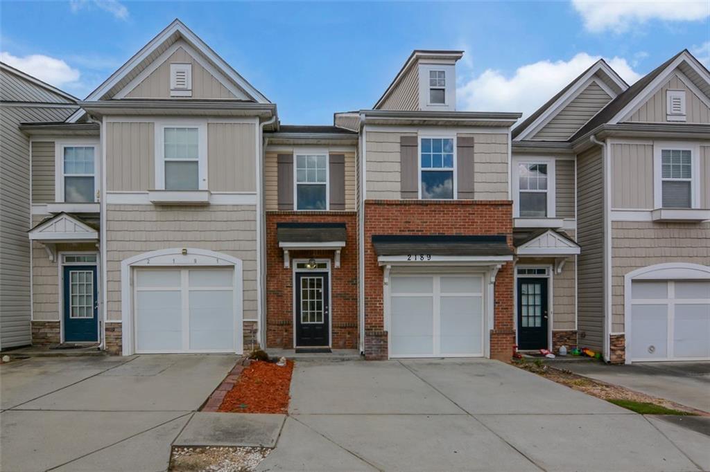 This beautifully refreshed townhome is move-in ready and ideally located with quick access to major highways, shopping, dining, and everything Duluth has to offer. With no rental restrictions, it's a fantastic opportunity for both homeowners and investors alike. Step inside to find a spacious living room featuring a cozy gas fireplace and a stylish wood accent wall that adds warmth and charm. The dining room with classic wainscoting flows seamlessly into the generously sized kitchen, offering great sightlines for entertaining or keeping an eye on little ones. A sliding glass door opens to a cozy patio surrounded by lush greenery, perfect for your morning coffee or evening unwind. Upstairs, enjoy three comfortable bedrooms, including a spacious primary suite, all with brand-new carpet and fresh paint throughout. Recent upgrades include a new AC unit, hot water heater, and kitchen flooring, giving peace of mind for years to come. This quiet and friendly community also features a gorgeous clubhouse and pool.