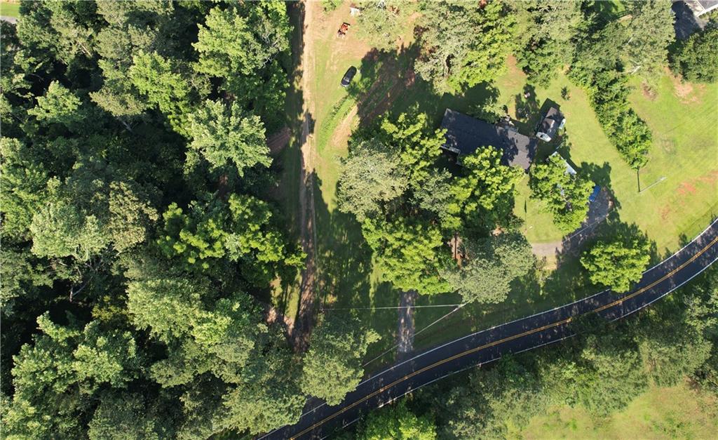 Exceptional opportunity for builders or investors—10.68 acres of partially cleared land in a highly desirable area. With Fourmile Creek winding through the property and A1 zoning in place, this parcel offers the flexibility to develop a private estate, mini compound, or multiple homesites. Property is already equipped with two additional build-ready sites, complete with electric, power, water and septic connections. The groundwork is set for immediate expansion. The existing mobile home provides a place to live or rent while you build. Access is via a quiet, secluded road—yet you’re just minutes from Lake Lanier’s beaches, top-rated schools, parks, and all the amenities of Cumming. Whether you’re envisioning custom homes, your dream estate, or a small farmstead, this property checks all the boxes: location, infrastructure, and development potential. Opportunity to purchase tracts separately. Appointment is required.
