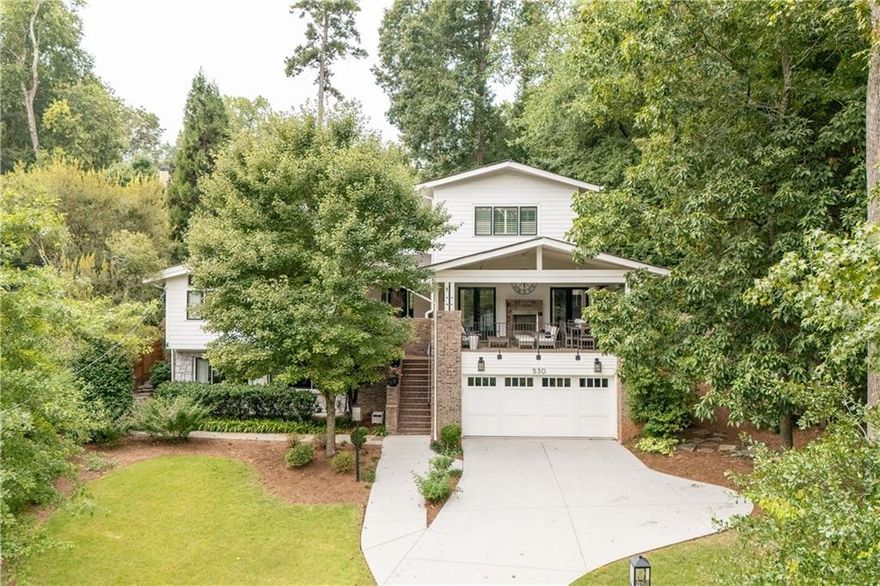 Only 0.3 miles from the heart of Oakhurst Village, this remarkable Arlene Dean/Eric Rawlins home blends modern sophistication with warm, livable spaces. From the moment you step into the welcoming foyer, dramatic windows flood the home with natural light, setting the tone for the elegant design throughout. The main level features a coveted primary suite with a spa-inspired bathroom, complete with soaking tub, expansive shower, and a dream-worthy closet. A second en suite bedroom on the main adds flexibility for guests, family, or a home office. Multiple living spaces make this home perfect for gathering, whether in the formal dining room that easily seats a crowd, the inviting den off the kitchen, or the elegant front living room with access to the front "treetop" porch. The bright, updated kitchen, showcasing a white-and-sublime blue cabinetry combination with honed marble countertops, overlooks lush backyard views and connects seamlessly to the outdoor living areas. The outdoor spaces are true showstoppers: Covered front porch with dramatic raised ceiling and fireplace that is ideal for dining al fresco and enjoying a treehouse-like perch   Back deck with a full outdoor kitchen   Private backyard with a stone fire pit, surrounded by greenery for total seclusion Upstairs, find two additional en suite bedrooms plus a light-filled loft, perfect for homework, reading, or play, with serene three-sided green views. The finished terrace level expands the home's versatility with polished stained-concrete floors, a kitchenette, full bathroom, and recreation room, perfect for an in-law suite or weekend entertaining. Don't miss the impressive 900-bottle wine cellar. This home offers a thoughtful blend of elegance and functionality, with multiple community spaces across all levels and finishes that elevate everyday living. A rare Oakhurst opportunity, just steps from the village, yet completely private. Come see what makes every nook and cranny so special.