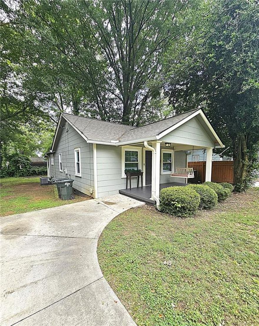 This cutie sits in an area that puts you minutes from the square of historic Marietta and on a street of neighbors who are a community and friends. Beautiful and mature trees frame the house. This open concept home with lots of windows inviting the natural light from outside into the home. Kitchen has stainless steel appliances and hood vent, granite counters and brand new luxury plank flooring. 2 bedrooms each having their own bathroom. The primary bedroom has brand new carpeting. The remainder of home has luxury plank flooring. Owner will leave the stacked washer/dryer combo. A fresh new coat of paint on the interior, upgraded windows, a new gas hot water heater and brand new heating and cooling allows you to move right in and enjoy yourself, spending your money on home decor or entertaining your guests. Enjoy the cute front porch swing with morning coffee or after work, and there is also a wonderful back porch that could easily be screened, if desired, for a more private outdoor experience. Level flat yard and a concrete pad which is perfect for fire-pit or a portable shed. Concrete parking area. Seller is offering a home warranty to purchaser. Come on home!
