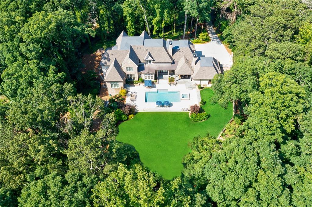 Stunning custom built estate situated on 4.7+/- acres in the heart of Buckhead. This gated property provides serenity and privacy on a hilltop setting.  Floor to ceiling windows from every room overlooking the walk out backyard is a highlight of this property. A true retreat in the heart of the city with an amazing pool and spa, outdoor loggia, chipping green and surrounded by a lush, beautifully landscaped yard. The owners suite located on the main level has a spa-like bathroom and spacious dual closets. Timeless design elements include hardwood floors, amazing trim detail and custom cabinetry throughout. State of the art kitchen features high end appliances and opens to the breakfast room and great room.  The floor plan is ideal for entertaining both indoors and out. Completing this home are two laundry rooms, four car garage, and spacious private suite with separate entry way.  The Terrace level includes an exquisite 1000+ bottle wine cellar, indoor batting cage, home gym, media room, guest suite and craft room. Truly an exceptional property with amazing amenities and style!