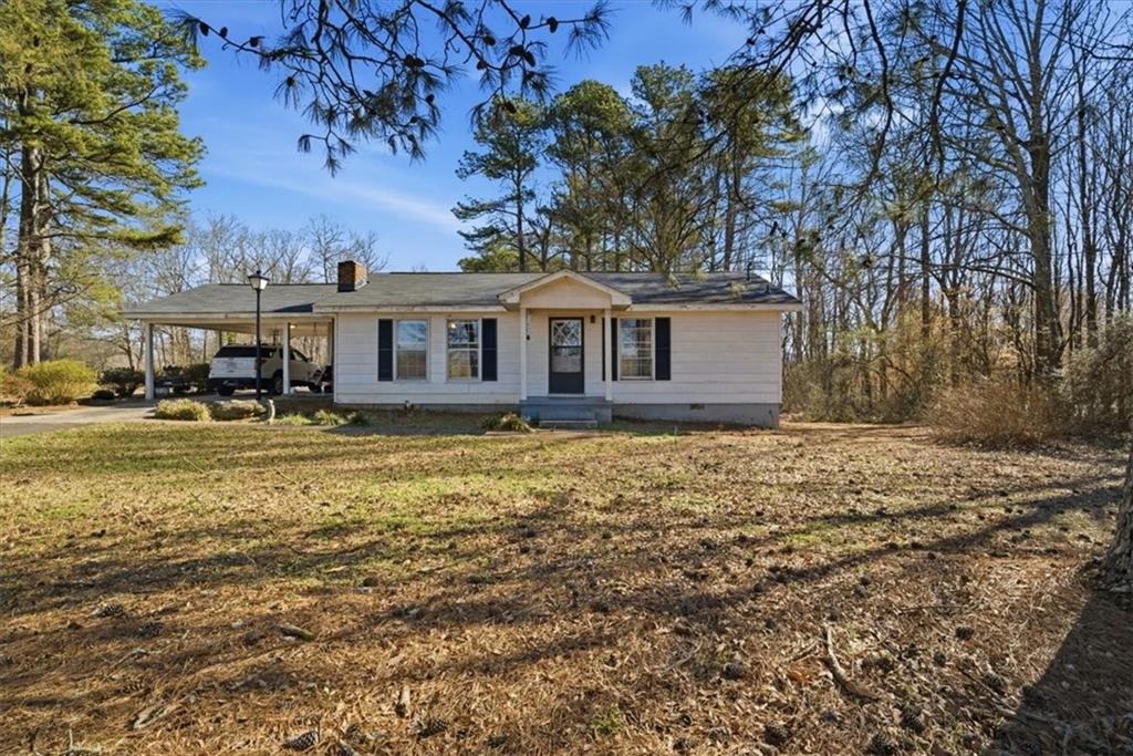 Single story home with a carport, out buildings and workshop