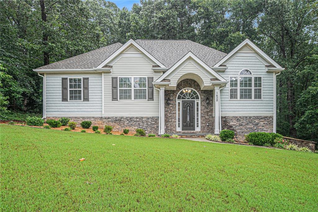 Welcome to 1428 White Oak Trace – A Private Retreat with Modern Upgrades in Loganville’s Top-Rated School District
Tucked away on a quiet cul-de-sac, this move-in-ready split-level home sits on nearly an acre of wooded privacy. From the moment you step onto the welcoming front porch, you’ll appreciate the thoughtful upgrades and peaceful setting this home offers.
Inside, you’re greeted by an open concept layout with fresh neutral paint, brand-new flooring, and soaring vaulted ceilings in the fireside great room. The renovated kitchen features white cabinetry, granite countertops, tile backsplash, and stainless steel appliances, all illuminated by natural light and modern fixtures. A formal dining room and sunlit breakfast nook offer options for entertaining and everyday living. The owner’s suite is a true retreat, featuring a tray ceiling, rich hardwood floors, and a beautifully updated bath that boasts dual vanities, a soaking tub, a separate shower, and stunning architectural details.
Downstairs, the fully finished lower level features a versatile studio apartment/in-law suite, complete with a large bedroom, sitting area, flexible space, and full bathroom—ideal for multi-generational living or accommodating guests. Want more room? Inside the finished garage is a separate 10x10 area you can use for a workshop, exercise room, or hobby area. A step outside and you’ll discover a true backyard oasis. The owner has transformed the outdoor space into a tranquil haven with professionally landscaped paths, a custom-built bridge over a creek, and a cleared picnic area tucked among the trees. The upper deck and covered patio offer multiple spaces to enjoy morning coffee, evening conversations, or weekend BBQs.Recent updates include a new roof (2018) and water heater (2021). All of this, located in the sought-after Loganville School District, close to shopping, dining, and parks.