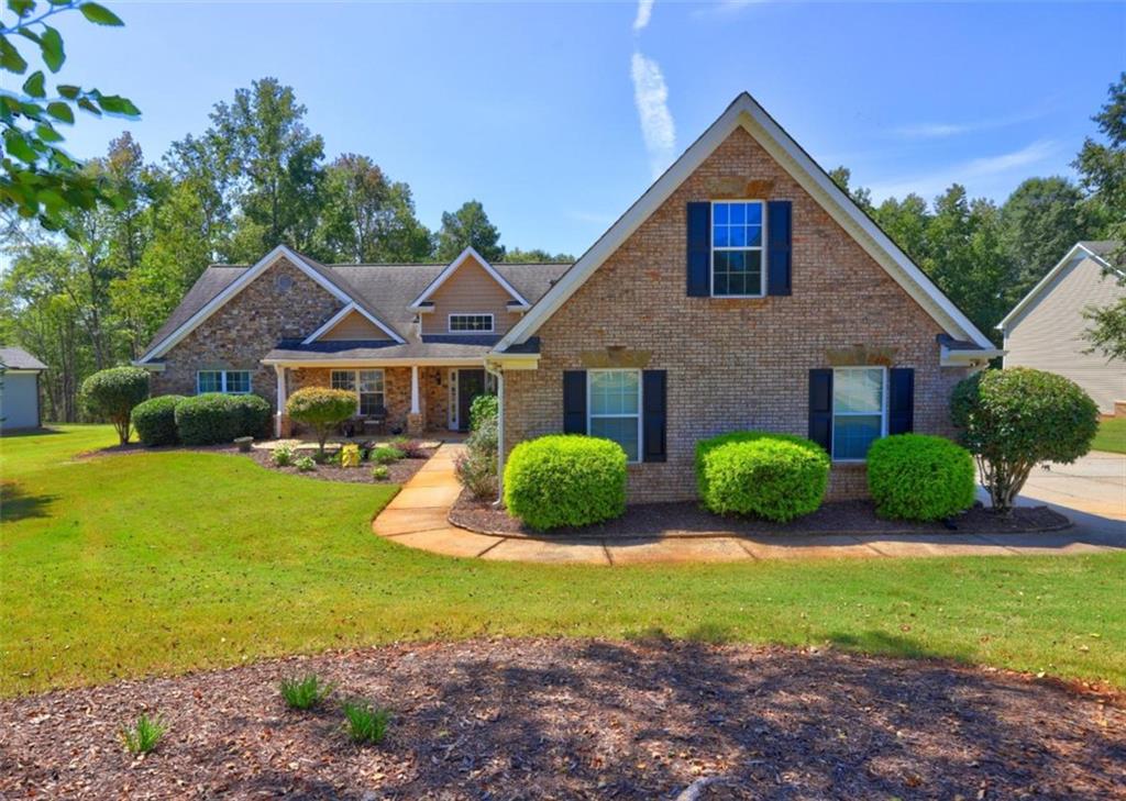 Welcome to this charming ranch home nestled on a spacious 1.03-acre lot in the desirable Gratis area. Featuring a beautiful brick and stone front, this home boasts a large great room complete with a cozy rock fireplace, perfect for gatherings. The open kitchen offers an abundance of cabinets, making it a chefs dream. With a split bedroom floor plan and a versatile bonus room on the main level, you'll have the flexibility for an office, extra den, or nursery. Updated LVP flooring throughout ensures a modern touch, making this home truly move-in ready. Enjoy the serene outdoors from the screened porch that overlooks a large backyard, complete with a workshop for all your projects. Don't miss the opportunity to make this lovely property your own!