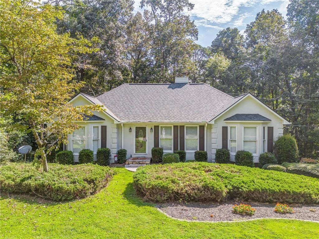 Welcome to 1023 Laurel Lake Drive, a charming 3-bedroom, 2-bath ranch-style home nestled on a private 1.2+ acre lot in the desirable Laurel Lake community. This thoughtfully designed split bedroom floorplan offers all main-level living, featuring a vaulted living room with a cozy gas log fireplace and luxury vinyl flooring throughout the main living areas. The spacious kitchen includes custom cabinetry, granite countertops, and a bright dining area that is convenient to the back deck—perfect for outdoor dining or relaxing!
The spacious primary suite offers a tranquil retreat with double closets and a spacious en suite bath complete with a garden tub and separate shower. The secondary bedrooms are generously sized, including one with a beautiful bay window that brings in natural light and adds a touch of charm.
Beautifully landscaped and situated on a quiet, tree-lined street, this home features a large two-car garage with additional depth—perfect for storing a third vehicle, boat, or ATV. An unfinished basement provides excellent storage or the potential for future finished living space. With an updated roof and a prime location just minutes from downtown Ball Ground's shops and restaurants, plus highly rated schools nearby, this home offers the best of comfort, convenience, and privacy. Schedule your private showing today!