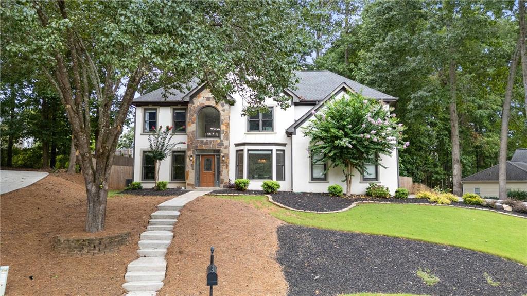 THIS is the ONE you have been waiting for! Milton HS district and walking distance to downtown Crabapple and The Green! This 5 bedroom home in a quiet cul de sac has it all at a price that is a rare find in this area! Featuring a full bath and bedroom on main this home checks all the boxes! Off the 2 story foyer you have an office/den and a beautiful dining room with accent wall. The fireside family room is so inviting with the natural light coming in from your wall of windows. The kitchen is an absolute dream featuring an oversized island and breakfast area. The cabinet space is exceptional! Upstairs you will find a spacious master suite with trey ceiling and a gorgeous updated bathroom with frameless glass shower and double sink vanity. Plenty of room for everyone with 3 additional well sized bedrooms and another full bath upstairs. The well appointed laundry room is also located upstairs. The wooded backyard features a fabulous covered patio. This is a great place to unwind or entertain. You will fall in love with the updates and style that abound throughout this home but don't take my word, get your showing scheduled TODAY before it's too late!