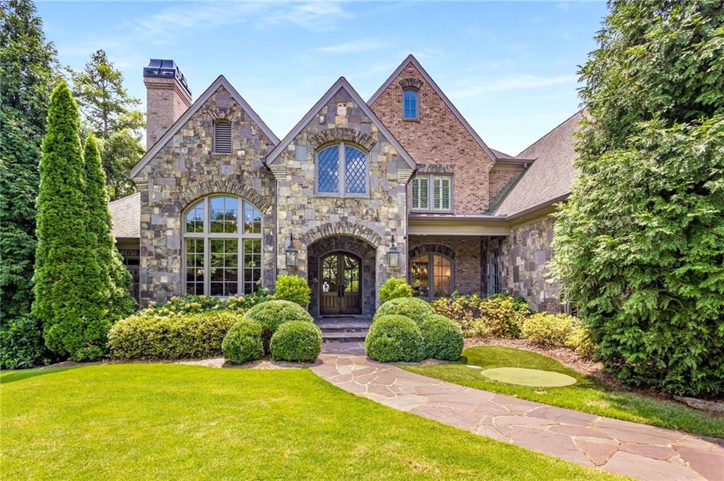 English Manor Estate custom built in 2009 by North Atlanta Properties minutes from Chastain Park in the heart of Sandy Springs, proudly
boasting approx. 13,000 sq ft of thoughtfully designed space. This luxury brick and stone home is graciously sited on a 3/4 acre corner lot,
behind layers of lush landscaping and a solid brick privacy wall, completely hidden from street view. As you pull in through the solid steel
and mahogany automatic car gate onto the interlocking paver driveway, you are taken aback by the incredible landscaping that fully
envelopes this lot. Step inside and see the perfect combination of modern conveniences with an elevated old world style! Walls of custom
iron doors/windows, exposed brick and stone archways, gas lanterns, stained tongue & groove wood ceilings, Palladian windows, Brazilian
Mahogany French Doors, rough hewn beams and more! Handsome main level study features 16' coffered ceilings, herringbone floors, hand
carved stained cherry paneled walls, fireplace with custom mantle with marble surround + grand Palladium window. Formal dining room
with custom trim, trey ceilings and is open to the formal living room with built-in bookcases and a custom hand-carved limestone mantle.
One of a kind kitchen features professional grade appliances, furniture style cabinetry, double dishwashers, multiple ovens, warming
drawer, refrigerator drawers, pot filler, huge island + separate professional chef scullery! The kitchen flows naturally through classic brick
and stone archways to the breakfast room and large family room w/built in book shelves and fireplace. Temperature controlled 300+ bottle
wine room and Butlers Pantry w/ice maker! Mud Room, Home Management/Office center and loads of storage throughout. Primary on main
features a double trey ceiling with rope lighting, floor to ceiling box bay window and custom iron doors! Spa bath features heated tile
floors, air jet soaking tub, steam shower with multiple heads and plenty of storage throughout. Primary closet has two distinct areas with
custom built-in shelving and center island. With multiple living spaces, each offering their unique experience, this home can accommodate
casual get togethers to formal dinners of 100+! The Sellers created a tremendous custom living space curated by the great Bill Harrison.
Accessed through multiple areas of the home through custom iron doors, this space is pure zen. The entire back wall is comprised of
custom, floor-to-ceiling, power iron windows that are operated by remote control. This jewel box of a room also features a custom two
level clear-story which allows for natural light to flow from every direction! 5 generous guest bedroom suites and bonus room upstairs.
Huge walk up attic with permanent stairs for additional storage! The finished terrace level doesn't disappoint. Large home gym, theater,
built-in custom wet bar, private guest suite, two full bathrooms, billiards room, fireside den, dining area and enclosed flex
lounge/entertainment space! The backyard is an oasis in the city! Professionally landscaped offering manicured privacy and featuring a
heated Pebbletec saltwater pool with waterfall, heated spa + patio of Pennsylvania Lilac stone & custom outdoor fireplace. Sited on a
corner lot which provide sidewalks + special turning lane for easy ingress/egress, walking & safe on street parking for guests. Whole house
generator, Control4, putting green and loads of extras - Welcome Home!