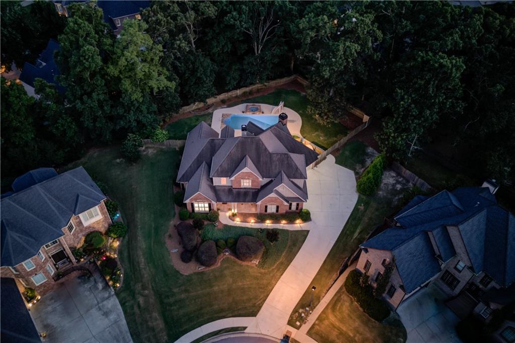HEATED SALTWATER POOL & SPA! ENTIRE INTERIOR HAS RECENTLY BEEN PAINTED "City Loft" by Sherwin Williams AND IS MOVE-IN READY! IMPRESSIVE, 4-SIDED BRICK & STONE ACCENTED, CUSTOM-BUILT, MOVE-IN READY HOME, FEATURING A 3 CAR SIDE GARAGE, A STUNNING GRAND ENTRY & MAIN LIVING SPACE, SOARING CEILINGS THROUGHOUT, AN OPEN CONCEPT FLOOR PLAN, AND A PRIMARY SUITE ON THE MAIN, ALL OVERLOOKING THE BACKYARD OASIS - HEATED SALTWATER POOL & SPA! This stately home is beautifully positioned on an elevated, private, oversized cul-de-sac lot - nearly 1/2 acre, with gorgeous landscaping and hardscape features throughout! Greeted by the beautiful, rocking chair front porch with a stunning DOUBLE DOOR entry, you are welcomed you into a bright, two-story grand open living space with SOARING CEILINGS, wrap around floor to ceiling windows showcasing the amazing RESORT STYLE backyard, PLANTATION SHUTTERS, NEW FLOORING, and a beautiful WOODEN staircase with wrought iron balusters - quite the first impression! The GOURMET KITCHEN features stained cabinetry, a gas cooktop, double ovens, stainless steel appliances, granite countertops, a tiled backsplash, and a center island. The keeping room is framed with elegant FLOOR TO CEILING columns that highlight the vaulted ceiling with EXPOSED BEAMS and a stunning stone fireplace - perfect for relaxation! The main level primary suite features a beautifully trimmed trey ceiling, a large, updated bathroom with a high, accented vaulted ceiling and chandelier that highlight the tub area, and a tiled shower. An additional office/flex area is also on the main floor with a double french door entry, an oversized window, and a vaulted ceiling. The second floor features a loft/office space with built-ins overlooking the main living area and three additional bedrooms. The private, fully fenced, BACKYARD PARADISE is ready for year-round entertaining and relaxation - a large patio area featuring an OUTDOOR KITCHEN space with a built-in Bull Grill, a heated saltwater swimming pool and stone accented spa with a WATER SPILLOVER, a NEW automated pool cover, a NEW PUMP, a DIVING BOARD and a SLIDE! The swimming pool and spa have been meticulously maintained, with a new liner, new pump/filter equipment, and new multi-colored Pentair lighting for those evening swims! Home has an irrigation system, HVAC system is one year old on the main floor and a Rheem tankless water heater (3 years old). Located just minutes to Downtown Buford, the Mall of GA, I-85, and within the new SECKINGER HIGH SCHOOL DISTRICT, you don't want to miss out on this amazing opportunity in the highly sought after ABERRONE COMMUNITY!
