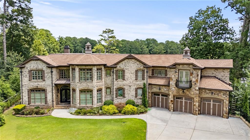 A rare opportunity in Decatur’s Oak Grove community, this Echo Lake estate sits on a ONE ACRE with private LAKE frontage in the exclusive Echo Lake neighborhood. Behind double glass doors, this THREE-STORY home opens into a soaring two-story living room with floor-to-ceiling windows that frame serene lake and treetop views. The main level is built to impress with coffered ceilings, an expansive open layout, and a CHEF'S KITCHEN anchored by a suite of Viking Professional Series appliances, French-door double electric wall ovens, and an 8-burner gas cooktop with pot filler. Striking stained glass windows add artful light to the space, while the dining room makes a statement with bold black-and-white checkered flooring and a dramatic chandelier. The richly appointed office mirrors that classic style with built-ins and a coffered ceiling. The 1500 SQ FT PRIMARY WING serves as a true retreat, featuring its own living room and fireplace, wet bar, dual powder rooms, multiple walk-in closets, oversized shower, separate garden tub, and a Juliet balcony, and two separate water closets. FOUR FIREPLACES are located throughout the home with two on the main floor, one in the private primary wing, and one on the terrace level. Outdoor living is elevated with a sun porch and separate deck overlooking the flat, landscaped backyard. The fully finished terrace level with walkout backyard access offers a movie theatre, wet bar, expansive entertaining space, and a guest suite. Located just minutes to Globe Academy, Emory, CHOA, and the CDC, with quick access to I-85 and I-285, and zoned for award-winning Oak Grove Elementary and Lakeside High, this is a home that blends scale, style, and sophistication in one of Decatur’s most sought-after enclaves. Echo Lake offers private lake access, trophy-worthy largemouth bass, bluegill, and redear sunfish, along with tranquil views just minutes from Atlanta. This coveted community, built around a pristine 18-acre lake, features beautiful homes, a welcoming neighborhood feel, and a voluntary Echo Lake Homeowners Association.