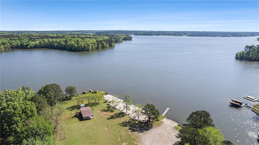 Don't miss this unique opportunity to own a fee simple lot in the desirable Sugar Creek Farms community, offering private access to Lake Oconee and a host of amenities for lakeside living. This property includes a 1999 Sunnybrook fifth wheel camper, enclosed porch, and a spacious 28x30 ft carport, making it the perfect getaway or full-time retreat, along with this property having it's own septic tank! Whether you're enjoying your morning coffee on the porch or launching your boat for a day on the water, this place has it all. The community features a private beach, a fishing pier, boat tie offs at the sewall, covered pavilion, and community bath houses! You will not find a better deal that gives you direct access to Lake Oconee! Whether you're an avid boater, a weekend fisher, or just looking for a peaceful escape near the lake, this property has everything you need to enjoy the Lake Oconee lifestyle without breaking the bank!
