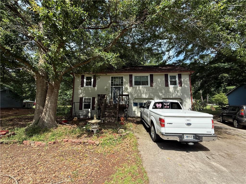Charming 3BR/2BA Split Foyer in Prime Covington Location! Welcome home to this beautifully maintained split foyer gem nestled in a convenient Covington neighborhood — just minutes from I-20, Covington Square's shopping and dining, and only a short drive to all that Conyers has to offer. Step inside to a cozy family/living room featuring a stunning stone fireplace, perfect for relaxing evenings. The galley-style kitchen boasts sleek stainless steel appliances and offers efficient, functional space for everyday cooking. The spacious owner’s suite is a private retreat, complete with a double vanity and a tub/shower combo. Two additional bedrooms are generously sized and share a well-appointed second full bath. Downstairs, a partially finished full basement provides endless possibilities — ideal for a game room, home office, gym, or extra storage. Step outside to a large, fenced backyard with a deck, offering plenty of room to entertain, play, or unwind in your own private oasis. Awesome double, detached garage with driveway extension.