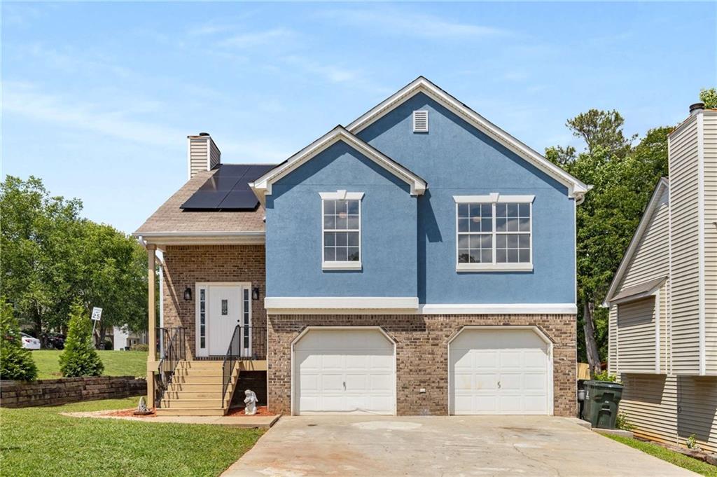 Welcome to this beautifully updated 5-bedroom, 3-bathroom home in Marietta offers space for every need. Tucked into a quiet neighborhood just minutes from Marietta Square, this home is full of thoughtful upgrades and modern charm. Step inside to find brand-new flooring and a bright, farmhouse-inspired interior with vaulted ceilings and a stunning stone accent wall. The custom glass stair railing adds a sleek, architectural touch that sets the tone for the rest of the home. The open-concept main level flows seamlessly from the living and dining areas into a kitchen featuring white cabinets, butcher block countertops, a classic subway tile backsplash, and sleek black stainless steel appliances. Natural light pours in from oversized windows, making every room feel open and inviting. The spacious primary suite offers a peaceful retreat, complete with a walk-in closet and a spa-inspired bathroom featuring a soaking tub, walk-in shower, and dual-sink vanity with custom finishes. Downstairs, the fully finished lower level is a standout feature. With its own kitchen, full bath, living space, and multiple rooms, it’s the perfect setup for an in-law suite, guest quarters, or even rental income potential. Step outside to a private, fenced backyard with a large deck and covered patio—ideal for entertaining or quiet evenings under the stars. Located on a corner lot, the home also offers extra privacy and plenty of outdoor space. With move-in-ready style, a flexible layout, and a prime location near shopping, dining, parks, and the Silver Comet Trail—this home is a rare find in one of Marietta’s most desirable areas. The solar panels will be removed, and the roof will be replaced with new architectural shingles before closing.