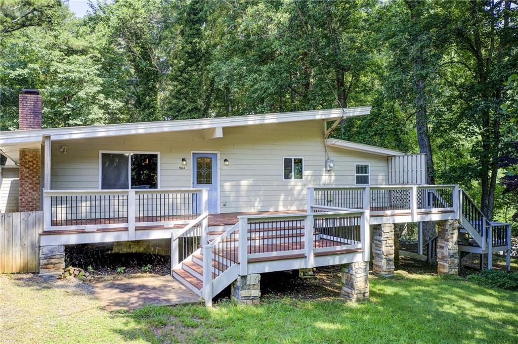 Lakefront Opportunity – Private Dock on Lake Allatoona | 3 Living Spaces | No HOA | Victoria Cottages
Welcome to your future lakefront sanctuary—just 30 steps from the water and your very own private deeded dock on the shimmering shores of Lake Allatoona. Nestled in the coveted Victoria Cottages community with no HOA, this rare property offers a one-of-a-kind opportunity: three distinct living spaces on a generous 0.4-acre lot. Whether you’re looking for a full-time residence, a weekend retreat, or an income-producing getaway, this home delivers unmatched flexibility and value. The main house features 3 bedrooms and 2.5 bathrooms, highlighted by a soaring vaulted ceiling and a cozy stone fireplace—perfect for relaxed evenings after a day on the lake. The open-concept layout connects the family room, dining area, and kitchen, making it ideal for entertaining or simply unwinding in comfort. Just steps away, the carriage house offers a private 1-bedroom suite with a bonus room, full kitchen, living room, and laundry—ideal for guests, extended family, or potential rental income. The terrace-level apartment includes a full bath and offers even more flexible living or storage space. Tucked beneath a canopy of trees, this lakeside hideaway is full of potential. Updates such as a metal roof, newer siding, HVAC, and windows provide a strong foundation for your personal touch. Enjoy morning coffee on your large front deck, host weekend gatherings under the stars, or take a short stroll to the dock for a spontaneous boat ride or swim. And if you’re dreaming bigger—the existing swim dock can be upgraded to a full boat dock (approval required from the Corps of Engineers). Located in the sought-after Etowah High School district, with quick access to I-575, Downtown Woodstock, Towne Lake, and The Outlet Shoppes of Atlanta, this home balances peaceful lakeside living with the convenience of nearby shopping, dining, and top-rated schools. This is more than a handyman special—it’s a Lake Allatoona lifestyle opportunity waiting for your vision. Whether you're dreaming of summer weekends on the water, cozy winter nights by the fire, or income-generating potential, the possibilities here are endless. Your lake dream starts now. Schedule your private tour today and unlock the full potential of this lakeside gem.