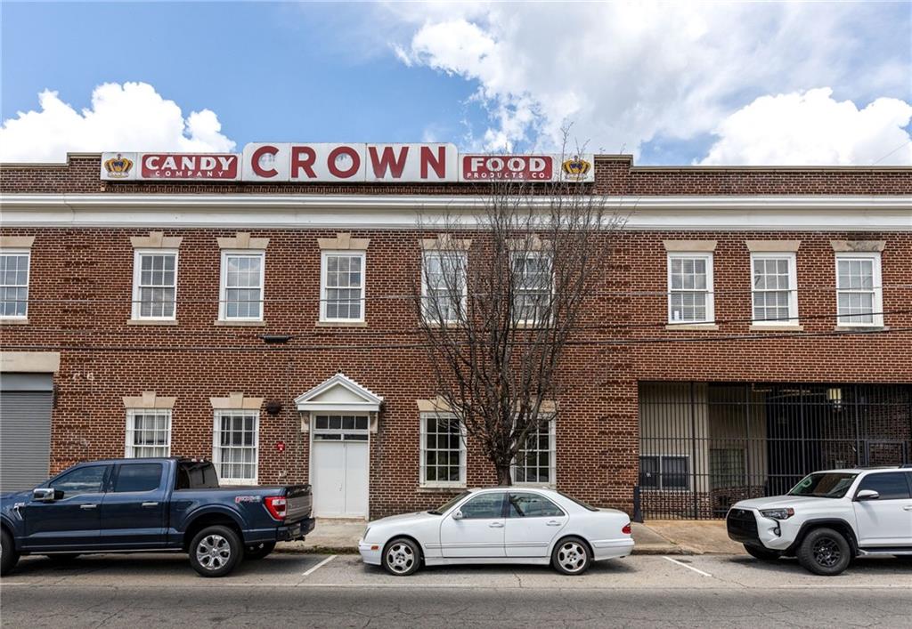 Lovely Crown Candy Loft, one-bedroom, two-bathroom loft with a fireplace in the heart of the neighborhood, this loft offers a unique blend of contemporary design and historic charm. Updated kitchen with modern appliances, countertops, plenty of cabinet space with a walk-in pantry. Updated bathrooms and a wall of windows, hardwood floors, bedroom loft that could comfortably fit a home office, eat in kitchen, laundry room. Walk to MARTA, Grant Park, Historic Oakland Cemetery, Ace Hardware, and restaurants and cafes. Boutique building boasts a rooftop deck (currently under full renovation) with breathtaking city views and a fabulous courtyard. 20' ceilings, exposed brick and historic factory details. The unit has a deeded parking space in an expansive covered garage.
