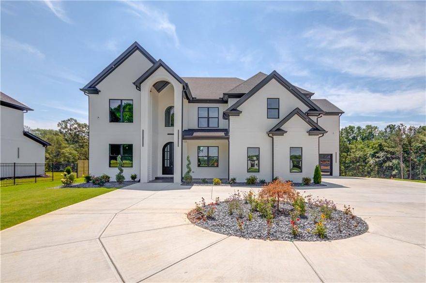 Nestled within a privately gated 2-acre expanse, this custom new construction home is a masterpiece of bespoke craftsmanship. Every corner whispers luxury with intricate tile and trim work adorning the interiors. The main floor unfolds to reveal a private office, formal dining room, and an exquisite chef's kitchen boasting stainless steel appliances, double quartz countertops, and a grand 48-inch gas range. Towering ceilings reaching 22 feet frame the living space where a striking fireplace and built-in cabinets create an ambiance of refined elegance. Step outside through glass doors onto the expansive back patio that overlooks the oasis-like backyard—a canvas awaiting your personal touch for adding a pool or pool house. The oversized primary suite on the main floor offers respite in its opulent en-suite sanctuary. This secluded haven beckons you to unwind amidst unparalleled beauty while being just moments away from all modern conveniences. Venture upstairs to discover four additional generously sized bedrooms, each boasting private bathrooms for ultimate convenience. A secondary living room awaits above, offering flexibility and space for relaxation or entertainment in equal measure. This residence epitomizes modern luxury living at its finest—an embodiment of refined taste and contemporary design.  This home is in close proximity to downtown Buford, Chateau Elan, restaurants, shops, Mall of Georgia, Gwinnett Exchange with quick convent access to highway 85 and highway 985. ESTIMATED COMPLETION SEPTEMBER 2024. BASEMENT OPTION IS AVAIABLE AT THIS TIME- CURRENT LIST PRICE IS FOR SLAB.