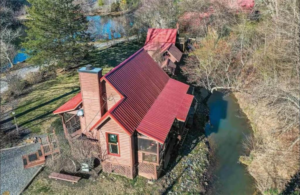Aerial view of property and surrounding area with a nearby body of water