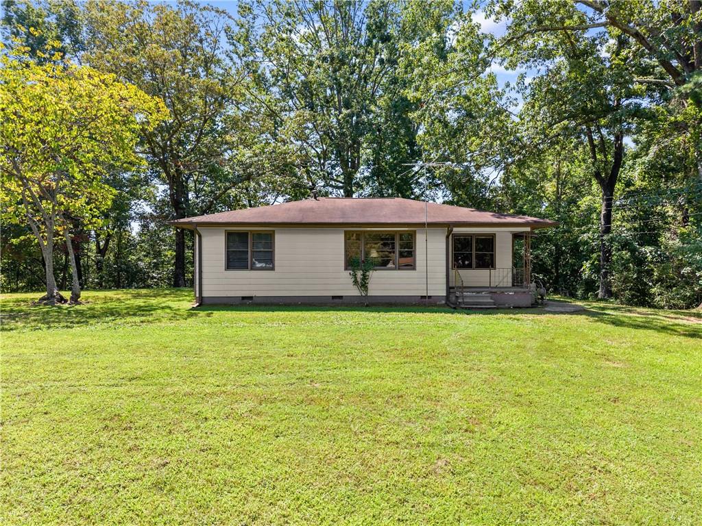 Discover peaceful country living on this 2.42-acre Hall County property, featuring a cozy 2-bedroom, 1-bath ranch-style home. Surrounded by mature trees and open yard space, this home offers the perfect blend of privacy and nature.
Inside, you’ll find hardwood floors, a spacious living room, and a vintage-style kitchen with abundant cabinet storage. The full bath includes a double vanity and tub/shower combo, making it practical for everyday living. Outside, enjoy plenty of usable land. Ideal for gardening, small animals, or simply relaxing in your own private retreat.
With endless potential for updates or expansion, this property is a rare find for first-time buyers, investors, or anyone seeking quiet acreage in North Georgia.