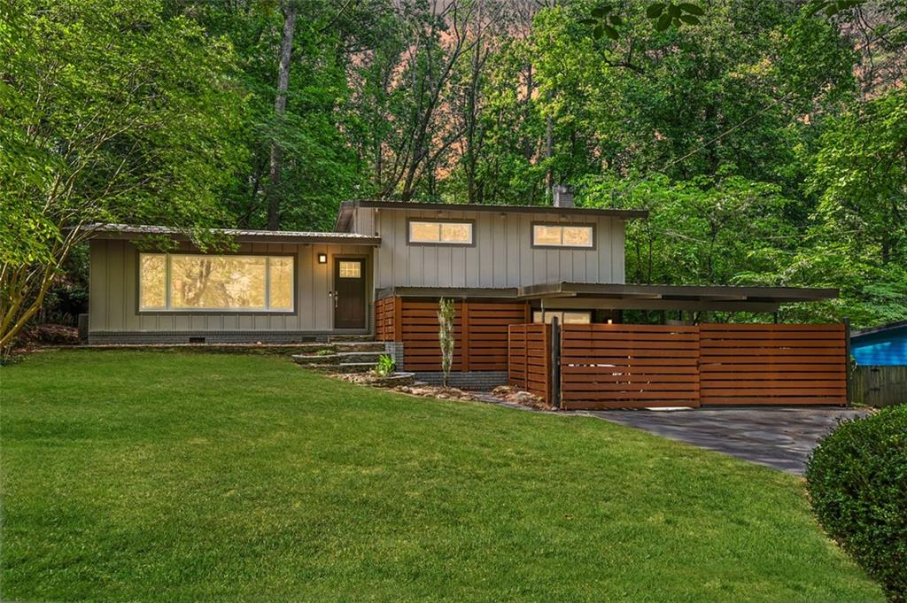 Why wait for the Fed to reduce rates? Seller may provide concessions that can be applied toward a 1% interest rate buydown with a qualified lender.* Tucked into the trees on an almost half-acre private lot, this beautifully refreshed 4-bedroom, 3-bath split-level home in the coveted Northcrest neighborhood blends mid-century architecture with modern updates. The exterior showcases a metal roof, stacked stone entry stairs, and horizontal fencing that enhances privacy while discreetly shielding the covered carport. Inside, vaulted wood-plank ceilings and hardwood floors create a warm, open atmosphere that flows effortlessly into the updated kitchen, featuring granite countertops, mosaic tile backsplash, modern cabinetry, a gas cooktop, and a brand-new dishwasher. Oversized windows frame the wooded surroundings and fill the living spaces with natural light.
The upper-level bedrooms boast fresh carpet and a full interior paint job, creating a clean, move-in ready feel. Multiple flexible living areas include a lower-level den with a decorative brick fireplace—ideal for a media room, office, or guest suite. Bedrooms are generously sized, showcasing vaulted ceilings, custom built-ins, and stylish barn-style sliding doors. Comfort and efficiency are provided by a Lennox central HVAC system, tankless water heater, and whole-home humidifier.
The nearly half-acre lot offers both privacy and room to enjoy outdoor living, while the 400-square-foot covered carport enhances the home’s mid-century aesthetic. Located in sought-after Northcrest—celebrated for its architecture, mature trees, and rolling hills—this home offers exceptional character and convenience, with easy access to I-85, I-285, downtown Atlanta, and Buckhead.
*All financing options subject to buyer qualification, lender approval, loan program guidelines, and market conditions. Not a commitment to lend.