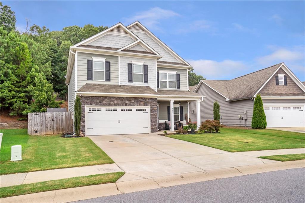 Nestled in the charming Creekside Village neighborhood of Hoschton, Jackson County, GA, this beautiful 4-bedroom, 2.5-bath is waiting for you to make it your home. As you step inside to a welcoming entryway you will be greeted with beautiful luxury vinyl floors throughout the main level, dining room, spacious living room with an open view to the kitchen. This stunning kitchen will be great for family meals and plenty of room to entertain guests with the beautiful Island, white cabinets, granite countertops and so much counter and cabinet space. As you travel upstairs you will be greeted with the spacious master suite with his and hers closets, a relaxing garden tub, and a separate shower plus 3 spacious secondary bedrooms and a full bath. Outside, this home has a covered front porch and a covered back porch with a fully fenced back yard. Ideally located just 20 minutes from the Mall of Georgia, this home offers easy access to premier shopping, dining, and entertainment. With its proximity to Hoschton City Park and quick access to I-85, this property is both a wonderful place to call home! All appliances remain including the refrigerator, washer and dryer and the seller is offering $2000 towards closing costs.