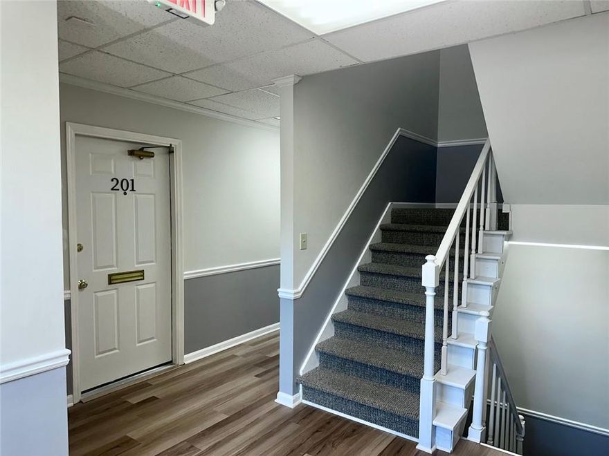 Suite 201 is a renovated and well-maintained office suite available for lease in the Williamscraft Office Park in Marietta. The suite offers approximately 1,329 square feet and includes a reception area, a break area with kitchenette, five private offices, and a bonus room. Two shared restrooms are available on each floor. The space features professional office lighting, hardwood floors, and a neutral color palette, making it ideal for a variety of professional users, including real estate offices, counselors, attorneys, CPAs, medical practices, and insurance firms. Current tenants in the building represent diverse industries such as technology, floral preservation, salon and medical spa services, construction, and logistics. The landlord is offering a gross lease that covers all expenses, providing a cost-effective and convenient solution for business growth. The property is located within the quiet Williamscraft Office Park, just off Sandy Plains Road, and benefits from excellent visibility with a traffic count of approximately 41,000 vehicles per day. The building offers two entrances, handicap accessibility on both floors, and 40 parking spaces. The location is highly convenient, with restaurants, markets, shops, and gyms within walking distance and easy access to I-75, I-575, Town Center, Kennesaw Wellstar, and Marietta Square.