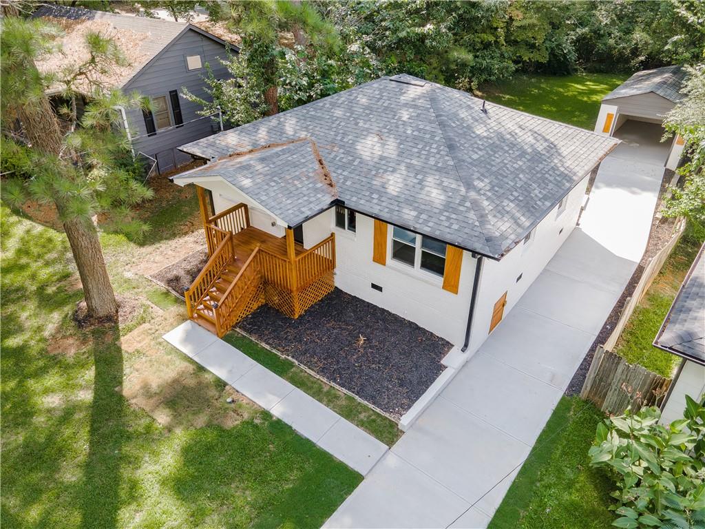 Welcome to this beautifully remodeled brick ranch that seamlessly blends modern design with classic appeal. From the moment you arrive, the stained, covered rocking chair front porch invites you to slow down and enjoy the charm of this thoughtfully updated home. Step inside to find gleaming hardwood floors and an open concept family room featuring a custom modern lighted accent wall, corner shelving, and an electric fireplace that sets the tone for cozy evenings and stylish living. The adjoining kitchen is a true showstopper boasting stainless steel appliances including a sleek vent hood, and a dramatic marble-inspired tile backsplash that extends from counter to ceiling. Sleek cabinetry and quartz countertops deliver a clean, modern aesthetic with just the right touch of traditional warmth. The primary suite features a beautifully updated bath with vertical subway tile. A trendy yet timeless design choice. Two additional secondary bedrooms and another full bath offer ample space, all updated with contemporary vanities, fixtures, and finishes. Outside, enjoy the new deck and extended concrete pad, perfect for parking or entertaining with wooded and private views. A detached garage offers even more storage and flexibility. With no HOA, you’ll enjoy the freedom to personalize your property as you see fit. Conveniently located near major highways, healthcare, top-rated schools, dining, shopping, and year-round entertainment. Just minutes from Mercedes-Benz Stadium, and Hartsfield-Jackson ATL Airport. This home checks every box for comfort, style, and location. Move-in ready and waiting for you!