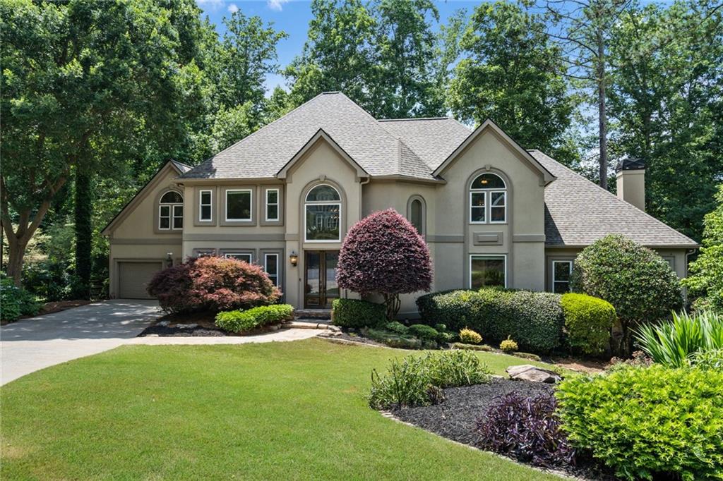 Stunning Hardcoat Stucco, Cul-de-Sac Home in Sought-After Asheforde Swim & Tennis Community. From the moment you arrive, the quality and elegance are evident starting with the grand double mahogany doors and continuing into a soaring two-story foyer with a sweeping curved staircase. Just off the entry, you'll find a formal living room or private office with coffered ceilings and a banquet-sized dining room featuring a tray ceiling -perfect for entertaining. Gleaming hardwood floors flow throughout the main level, leading into the impressive two-story great room where expansive windows flood the space with natural light. The updated, open-concept kitchen flows seamlessly into the great room and boasts premium stainless-steel appliances, including a Bosch dishwasher, Wolf gas cooktop, and GE double ovens. Skylights brighten both the vaulted breakfast room creating a warm, inviting space for gatherings. French doors open to a massive rear deck overlooking a sparkling, Saltwater Pool with New Vinyl liner, flagstone decking and grassy lounge area. The fenced backyard includes a separate play area or space for a firepit—ideal for entertaining or relaxing with family. The desirable main-level primary suite is a true retreat, complete with a hardwood floors, a cozy fireplace, luxurious spa-style bath featuring a soaking tub, heated floors, and custom his-and-her walk-in closets with built-ins. Upstairs, you’ll find four spacious bedrooms—two with en-suite baths and two that share a Jack-and-Jill bath with separate vanities. The full daylight terrace level offers fantastic flex space, including an exercise room, a spacious RecRoom with wet bar, a full bath, and a separate office with built-ins. Additional highlights include A New Roof, energy-efficient windows thru-out and solid oak hardwood flooring. This move-in-ready home is perfectly positioned in a popular clubhouse community with access to swim, tennis, a playground, and miles of scenic trails that connect to the Chattahoochee National Recreation Area and the Gold Branch trail system. Enjoy close proximity to Roswell’s vibrant dining and entertainment scene, as well as convenient access to major roadways like GA-400, I-75, and I-285. Zoned for the award-winning Mount Bethel Elementary, Dickerson Middle, and Walton High School.