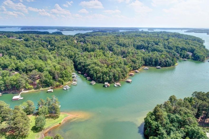**UNBELIEVABLE PRICE!!**Custom-Built Lake Lanier Retreat – A Builder’s Personal Masterpiece**

Welcome to a perfectly maintained brick and stone home on the shores of Lake Lanier, built and owned by the builder himself—where quality craftsmanship meets lakeside living. Every inch of this home was thoughtfully designed with expanded room sizes, custom accent walls, heavy trim, and attention to detail in every room.

Step outside and launch your kayak, cast a line, or simply relax by the water—this lush one-acre property offers direct lake access right from your backyard. A spacious front porch is the perfect spot to unwind as deer graze nearby, and the oversized back deck sets the stage for peaceful sunset dinners. Gather around the fire pit and soak in the serenity of your private retreat.

Inside, the home impresses with a two-story family room filled with natural light, a warm keeping room off the large kitchen, and a generous breakfast area perfect for casual mornings. The kitchen is a dream with abundant cabinetry and workspace. Main level living includes a bedroom and full bath, an office with built-ins, and a formal dining room for entertaining.

Upstairs features large secondary bedrooms, a bonus/media room ideal for movie nights or play space, and a stunning owner’s suite with a completely remodeled bathroom and custom closet shelving.

An unfinished basement offers room to grow or customize. The home also boasts a newer roof, new interior and exterior paint,  300-amp electrical service, irrigation system, speaker system throughout the home, new flooring and more!!! AND, it is just seconds from a boat ramp, park, playground, and picnic pavilions.

This is more than a home—it’s a lifestyle!