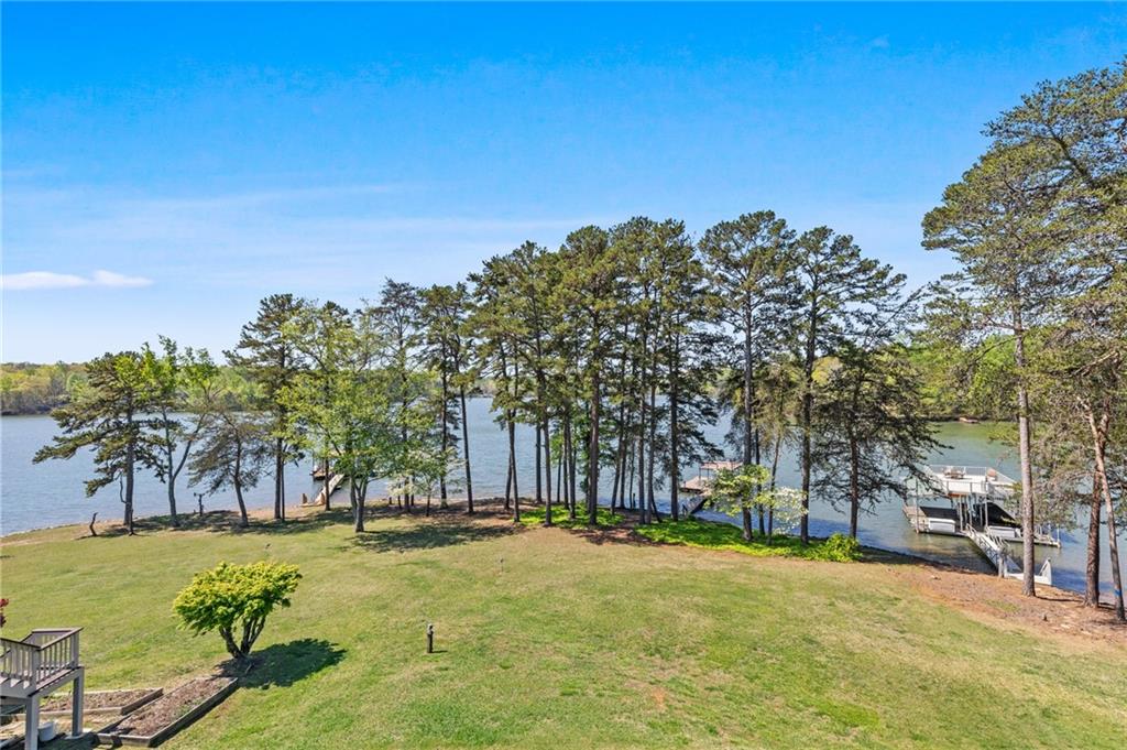 Welcome to your dream lakefront getaway! This gorgeous home is situated on a level lot, offering quick access to the water's edge. Enjoy sweeping, uninterrupted lake views from every floor and each bedroom. The main floor features a soaring vaulted ceiling and a spacious open layout that connects the kitchen, living room, and dining area. A bedroom and full bath on the main level provide a flexible living space. Designed for both comfort and elegance, this property features a seamless indoor-outdoor flow. The beautifully updated deck and roomy screened porch provide space for dining, lounging, and enjoying the view. Retreat to the luxurious upper-level primary suite, boasting picture perfect water views, a walk-in closet and a private balcony overlooking the property. A secondary upstairs bedroom provides a large walk-in closet and space for guests or a private study. The spacious full bathroom features double vanities, a beautifully tiled shower, and a modern bidet for added comfort. The terrace level offers a second family room with sliding doors that open directly onto a private patio. The well-appointed bedroom and full bathroom offer convenience and privacy for guests or family members. Step outside and stroll a few steps to your private remodeled dock with boat lift and party deck. Deep water awaits- perfect for boating, swimming, or simply soaking in the peaceful surroundings. Located minutes away from Athens Boat Club and a relaxing boat ride away from local marinas including Aqualand, Port Royale and Holiday. Whether you're entertaining or enjoying a quiet sunset this home is a true lakefront masterpiece. Don't miss this rare opportunity to own a slice of paradise!