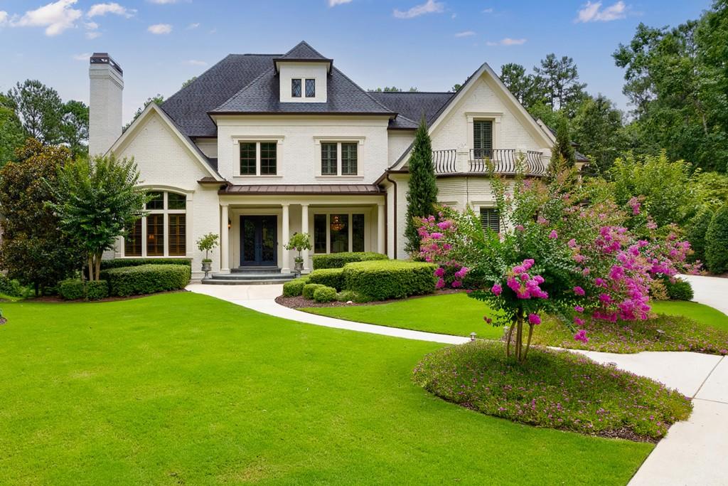 Experience your summer resort at home! This exquisite, custom designed all-brick home with the owner's suite on the main level is an entertainer's paradise, with every detail to the finest degree. Nestled on a premium, private cul-de-sac lot with a luxurious resort pool and stunning golf course views of the 5th green and fairway in sought-after gated Governors Towne Club, this immaculate home is move-in ready. You and your guests are greeted with the beautiful, lush landscaping and the stunning elevation of the home. As you enter through the custom iron doors, the grand two-story foyer with streaming light impresses with the adjacent stately oak-paneled office with a fireplace and 12-foot ceilings. A beautifully appointed, generously-sized dining room leads to the grand living room with soaring ceiling heights. The light-filled, multi-level living room is uniquely situated with French doors leading to an expansive two-story covered veranda, with a grand cozy fireplace and breathtaking views. This is a great space for relaxing and entertaining. The elegant designer kitchen, with custom cabinetry, high-end appliances and a large walk-in custom pantry, features an oversized island with updated quartzite countertops. The kitchen is the perfect space for gatherings since it overlooks the large family room with vaulted ceilings and a beautiful stone fireplace. This oversized area provides easy access to the two-story covered veranda. The owner's suite on the main level is its own private retreat with its double door entry, an exquisite 15-foot trey ceiling with sitting area and coffee bar. Behind another set of double doors, the master bath has separate vanities, an oversized travertine tile shower, large jetted spa tub and a generously-appointed, custom-designed master closet. Enjoy the easy access to the veranda overlooking the pool from your owner's suite. On the second level of the home, there are four additional oversized ensuite bedrooms, offering plenty of space and privacy, each with their own custom finishes, ceilings and walk-in closets. Conveniently, a second large laundry room with custom cabinets is available upstairs. The resort-like, professionally landscaped grounds offer privacy for enjoyment of the self-cleaning, 39,000-gallon saltwater pool and spa surrounded by tropical landscape, waterfalls and multiple lounging areas for year-round enjoyment and entertaining. The large, unfinished daylight basement with 10-feet ceilings and approximately 3,900 square feet offers endless possibilities for future use. The superior construction and charm of this wonderfully appointed home provides the perfect space for working from home and a luxury lifestyle. Enjoy all the gated community has to offer with the championship golf course designed by U.S. Open Champion Curtis Strange, stunning clubhouse, spa, activity center, tennis courts, Olympic-sized pool and neighborhood events; all within the secure, gated community of Governor's Towne Club. When you choose to venture out, enjoy the nearby Allatoona Yacht Club to house your boat and enjoy the local lakes as well as shopping and dining in local areas. Convenient access to I-75 gets you to Atlanta in less than 30 minutes. Welcome home to your new lifestyle!
