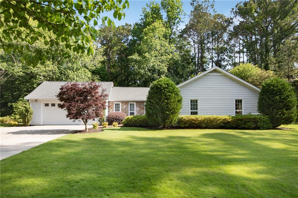 Here is the hard to find ranch you have been looking for! 3 bedroom, 2 bath on a beautiful level lot. What more could you ask for? Great curb appeal! Large fireside family room walks out to the patio overlooking the backyard that feels like you are in a park. Kitchen features granite counter tops, stainless appliances, plenty of cabinets for storage, built-in desk, breakfast/dining area, and a built-in china cabinet (that is a secret passage way into the garage-great for moving furniture in!). The two spacious secondary bedrooms and the primary suite are on the opposite side of the home. The full bath in the hall has been recently updated. This one will not last! Close proximity to Sope Creek Park, I-75, and Truist Park/Battery. Taxes reflect senior exemption.
