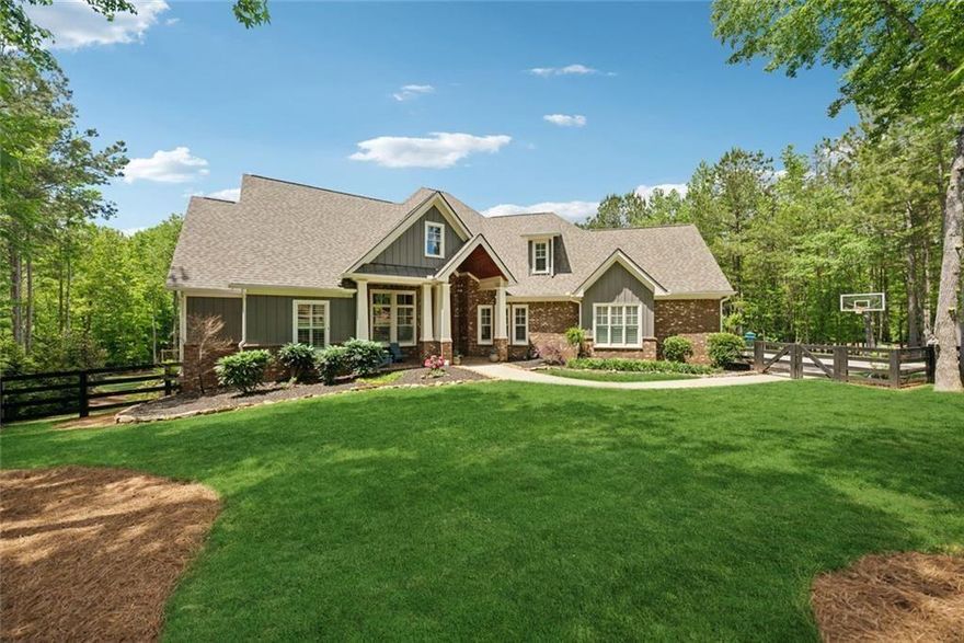 Privately situated on 2.23 acres in the prestigious Estates at Serenity Farm, this 6-bedroom, 5-bathroom residence offers 6,625 square feet of luxurious living space, enhanced by thoughtfully curated upgrades both inside and out. A true entertainer’s dream with a resort-style backyard pool and designer interiors, this home offers elevated everyday living in the heart of Southeast Cherokee County.
Step into a grand two-story foyer that opens to an inviting great room with wood-beamed ceilings, a cozy fireplace, and a wall of windows. The open-concept kitchen is a showstopper—featuring upgraded stone countertops, a large prep island with built-in microwave, and a spacious eat-in peninsula perfect for casual dining. A stylish gray herringbone subway tile backsplash adds texture and polish, while the 6-burner gas range, stainless steel appliances, walk-in pantry, and custom cabinetry complete the chef’s space. The breakfast area and fireside keeping room flow effortlessly into the screened porch with a second fireplace for year-round enjoyment.
The main-level primary suite offers a spa-inspired bathroom with dual vanities, oversized shower, soaking tub, and two walk-in closets with direct access to the laundry. Two additional main-level bedrooms share a Jack-and-Jill bath with built-in study nook, and a fourth ensuite bedroom offers flexibility for guests or a home office. Upstairs you'll find a private guest suite with full bath and sitting room.
The daylight terrace level has been beautifully finished with 2,689 sq ft of flexible space, including a media room with 7:1 surround sound and noise-dampening ceiling, a full wet bar kitchen with beverage coolers, ice maker, and kegerator, a family room that opens to the covered patio, gym, and game room. An additional bedroom, full bath, and second laundry room offer the perfect setup for multi-generational living or as a teen suite.
Outdoors, a newly completed pool and spa create a five-star experience at home—featuring an 18’x36’ heated pool with tanning ledge, 8’x8’ spa, in-floor cleaning system, travertine decking, copper fire bowls, and a gas stone fire pit. The fully fenced backyard has been professionally transformed with new grading, stone retaining walls and steps, lush Zeon Zoysia sod, full irrigation with drip system.
Additional upgrades include plantation shutters throughout, under-decking for the covered porch, and a fourth HVAC unit added. A spacious 3-car garage and a prime location close to Milton, Alpharetta, and top-rated schools make this property a rare opportunity in one of Cherokee County’s most desirable estate communities.