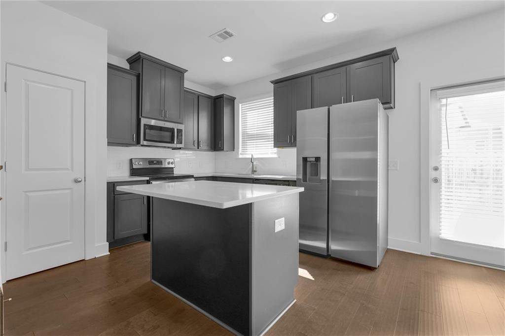 This beautifully designed townhome offers an abundance of natural light throughout its open concept floor plan. The home features 3 bedrooms, 2.5 bathrooms, a 1-car garage, and a driveway accommodating up to 2 cars. The interior boasts elegant stone countertops, a gorgeous designer backsplash, stunning dark cabinets with silver accents, and stainless steel appliances. Enjoy the convenience of an included washer and dryer on the top level. The master bath is a luxurious retreat with a separate tub and shower, double vanity, and a spacious walk-in closet. The additional bedrooms are generously sized. This home is ALL HARDWOOD FLOORING, adding to its charm and easy maintenance. The fully fenced yard is perfect for entertaining, and lawn care is maintained by the HOA. Located in a beautiful new community in Stonecrest, you’ll be near shopping, grocery stores, Stone Mountain, and I-20. Plus, the home is right across the street from Redan Recreation Center. Don’t miss out on this stunning rental opportunity!