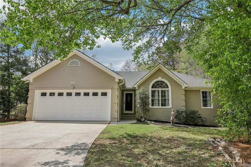 Dive into summer with this stunningly updated home featuring a sparkling pool! Step inside to gorgeous, easy-to-maintain LVP wood floors that flow throughout the living spaces. The inviting living room features soaring vaulted ceilings, a cozy fireplace, and an abundance of natural light. A breakfast bar leads to the beautifully updated kitchen, complete with solid surface countertops, shiplap accents, sleek white cabinetry, and elegant light fixtures. Enjoy poolside views from the bright and airy dining room, featuring a charming bay window. Retreat to the spacious primary suite with a sophisticated tray ceiling and a fully updated en-suite bath, offering dual vanities, a custom-tiled frameless glass shower, and stylish shiplap walls. Two additional spacious bedrooms and a full hall bath provide ample room for family or guests. Step outside to your own private backyard retreat! The fully fenced yard features a sparkling in-ground pool, a generous deck perfect for entertaining and grilling, and lush green space—all backed by the serene privacy of mature trees. Just minutes away from the East-West Connector and  Powder Springs Road, it, offers convenient access to a variety of restaurants, shopping, and entertainment options. Don't miss this incredible home—your summer oasis awaits!