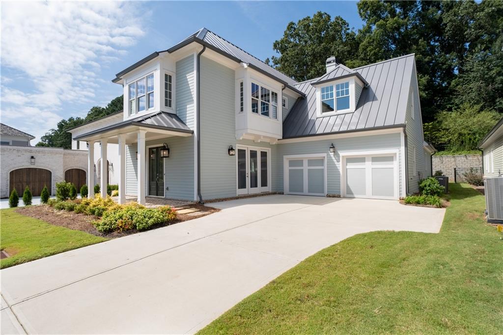Ask about our preferred lender incentives and a 5% rate! Discover a home that perfectly balances elegance, comfort, and versatility in the heart of Vickery. This 5-bedroom residence offers a thoughtfully designed layout with flexible spaces to fit your lifestyle. One main-level bedroom doubles as a private home office, while the upstairs flex room easily transforms into a junior suite, media lounge, or guest retreat. The primary suite is conveniently located on the main level, creating a private haven just steps from the heart of the home. A formal dining room sets the stage for memorable gatherings with its brick accent walls and cozy fireplace. The chef’s kitchen is a true showpiece, featuring a 36-inch Wolf gas range, sleek vent hood, quartz countertops, ceiling-height soft-close cabinetry, and a walk-in pantry with custom wood shelving. The inviting great room boasts tongue-and-groove planked walls and a fireplace, seamlessly opening to a covered brick porch with soaring ceilings. Extend your living outdoors on the brick patio, complete with a stone wood-burning fireplace—ideal for al fresco dining or relaxed evenings under the stars. Upstairs, the junior suite includes a built-in workspace for remote work or study, while three additional bedrooms—two with en-suite baths—offer comfort and privacy for family and guests. Just minutes from the shops and restaurants of Vickery Village, this golf cart-friendly community also offers access to the Forsyth County YMCA. Here, you’ll find not just a home, but a lifestyle defined by convenience, connection, and charm.