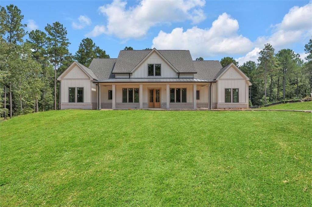 Harmony Bay at Lake Oconee — 2025 Custom Single-Story on 1.75 Private Acres
Brand new home just completed inside the gated community of Harmony Bay, this single-level custom home offers refined lake-area living on 1.75 private acres. With 5 bedrooms and 4.5 baths, the design blends craftsmanship with casual elegance in an effortless, open layout.
The vaulted great room draws the eye with wood-beamed ceilings and a dramatic floor-to-ceiling brick fireplace—an inviting centerpiece for everyday living and entertaining. The designer kitchen impresses with ZLINE stainless steel appliances, custom cabinetry, an oversized island, and a spacious walk-in pantry complete with a wine refrigerator—equal parts beautiful and functional.
The private primary suite is a serene retreat featuring a spa-inspired bath with a freestanding soaking tub, floor-to-ceiling tiled shower, double vanities, and a generous walk-in closet. Guest accommodations include three secondary bedrooms on the opposite wing with access to beautifully finished baths, plus an additional bedroom that flexes easily for guests, office, or media.
Step outside to expansive covered outdoor living with a wood-burning fireplace and a large, private backyard—plenty of room to add a custom heated saltwater pool. An oversized boat garage keeps watercraft and lake gear neatly stowed. Enjoy Harmony Bay’s private community boat ramp for effortless lake days, along with a prime location minutes from Lake Oconee’s top restaurants, schools, shopping, and golf.