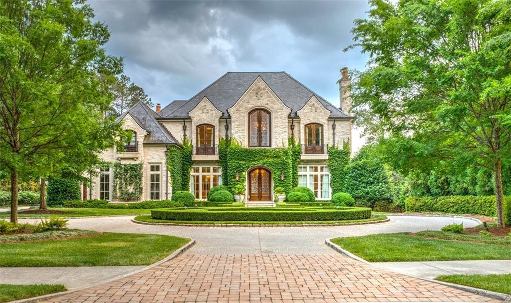 See Drone Video. Serene lake frontage estate overlooking the 7th Fairway. Most exquisite house+setting in North Metro Atlanta. $2,000,000 invested above tax record $$. Indiana Limestone exterior. Vermont Slate roof. Dark wide plank walnut floors on main & top floors. Terrace level has Beaumaniere limestone floors.Light-filled neutral design with supreme construction provides a move-in ready home for the most discerning buyer. 12’ ceilings on Main including the Master suite.3 levels with covered porches & breathtaking views