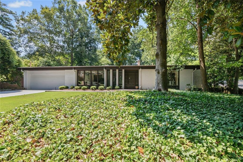 Welcome home to this stunning true mid century modern masterpiece. Designed and built in 1963 by the original owner, this home features everything you could hope for. Situated on a full half-acre you will appreciate walking through the front door with a direct view across the sunken living room to the expansive pool and deck area. Palm Springs in Atlanta! Featuring two bedrooms, an office that can be a third bedroom and three full bathrooms all on one level. The formal dining room features floor to ceiling windows and is located just off the galley kitchen, which features skylights to let in endless natural light. Adjacent to the galley kitchen and sunken living room is a breakfast area that leads to a solarium area perfect for playing cards. You’ll find a full bath and a wet bar too. The owner’s suite features expansive views of the pool and deck and includes an en-suite bathroom complete with massive walk in shower, separate water closet and skylights. You will also find ample closet space with the walk in closet. The secondary bedroom features a walk in closet and is situated at the front of the home. A full bathroom and laundry are also on the main level. There’s a bonus room below the pool area that formerly included a hot tub and is ideal for renovation or storage. Mature landscaping makes this home a must see. Minutes from Buckhead Central, Northside Drive and Bobby Jones Golf Course. Shopping, schools and entertaining are convenient as well.