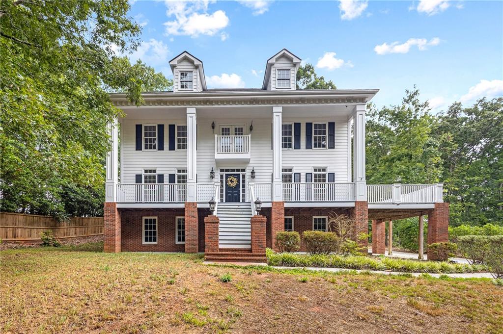 Welcome to this stunning, character-filled home that seamlessly blends timeless charm with modern updates. From the moment you arrive, you'll be captivated by the elegant exterior featuring stately columns and a grand front staircase that leads to a covered wrap-around porch—perfect for morning coffee or evening relaxation. Step inside to soaring ceilings and an inviting staircase that sets the tone for the home's open and airy layout. The main level features a flowing floor plan with a formal dining room ideal for entertaining, and a spacious kitchen that opens to the living room for effortless gatherings. The kitchen is a chef’s dream, complete with granite countertops, stainless steel appliances, double ovens, and ample cabinetry. Upstairs, retreat to a luxurious master suite that boasts an abundance of natural light, a large walk-in closet, and a spa-inspired en suite bathroom with dual vanities, a soaking tub, and a tiled walk-in shower. Additional bedrooms upstairs are generously sized with brand new carpet. The walkout basement offers incredible flexibility with an additional bedroom and full bathroom—perfect for guests or extended family. Already plumbed for a kitchenette, this space is ready to become a mother-in-law suite, recreation room, or home bar—the choice is yours. Additional features include fresh interior paint, recessed lighting, and modernized bathrooms throughout. The home also includes three garage spaces, offering ample room for vehicles and storage, and sits on a well-sized yard ready for your outdoor plans. Don’t miss your chance to own this character-rich home with exceptional space, style, and functionality!