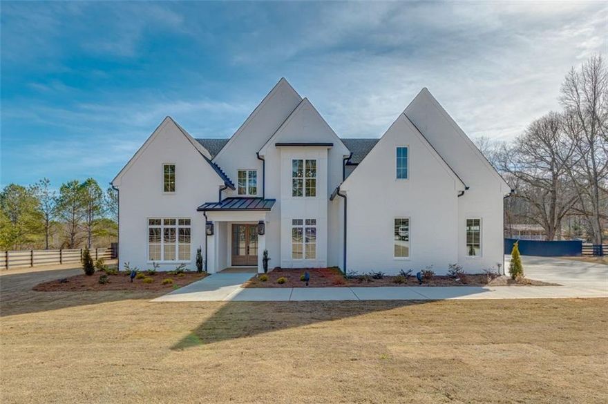 Welcome to this impeccably crafted custom home boasting upgrades throughout. This stunning residence features 5 bedrooms, 6 full baths, 2 half baths, along with a 4-car garage, perfectly suited for accommodating the entire family. Situated on 3.311 acres of private land , fenced-in backyard, this estate offers a pristine, level landscape. The highlight of the outdoor space is the heated saltwater oasis, complete with a custom pool, hot tub, and spa. Upon entering, you are greeted by a grand 2-story foyer leading to a custom-appointed office and a versatile flex-space, ideal for formal living or dining, complete with a bar area. Continuing through the home, you'll find a spacious great room featuring a coffered ceiling, a striking floor-to-ceiling fireplace, and custom cabinetry. The kitchen is a dream, boasting an oversized island, quartz counters, professional-grade stainless steel appliances, an oversized walk-in pantry. Tucked away in the back, you will find the prep kitchen which offers a secluded spot to prepare food and drinks, away from the hustle and bustle of open concept kitchen. The main level master suite is a luxurious retreat, offering a vaulted ceiling, ample natural light, and French doors leading to a spa-like bathroom. Upstairs, four individually appointed mini-master suites each feature their own bathroom and custom walk-in closet. Additionally, there's a second laundry room and a generously sized loft area with a fireplace and mini-kitchen, perfect for entertaining. For outdoor enjoyment, step outside from the gourmet kitchen to a covered patio with an outdoor kitchen, pellet smoker, prep counters, and open shelving. A custom fireplace adds ambiance to the outdoor space, which overlooks the private aquatic oasis enclosed by privacy fencing. Conveniently located just minutes away from the brand-new Harbins Road development, offering access to Publix, dining, shopping, and entertainment. This home is also a short drive from Downtown Dacula, Buford, Lawrenceville, and approximately 30 minutes from the University of Georgia and Athens area. Welcome home to luxury living at its finest!