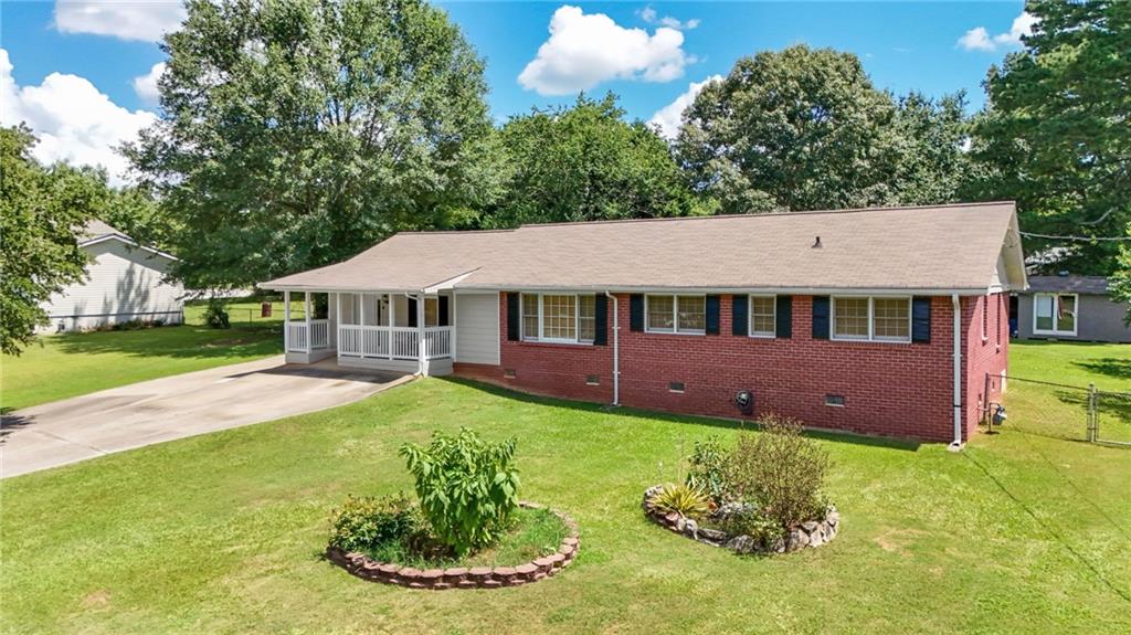 Charming 3BR/2BA Ranch with Detached Garage & Workshop! Welcome to this cozy ranch home ideally located on a quiet street just minutes from Hwy 78, Hwy 124, I-285, shopping, dining, and the scenic Stone Mountain Park. This well-maintained 3-bedroom, 2-bathroom home offers a bright and airy family room with laminate flooring and a cozy fireplace. A separate formal living room provides the perfect setting for gatherings or quiet evenings. Sitting on a beautifully landscaped 0.41-acre lot, the property features fruit trees, a fully fenced backyard, and a spacious deck perfect for outdoor entertaining or relaxing. You'll also appreciate the detached 2-car garage with an attached workshop, ideal for storage, hobbies, or weekend projects.