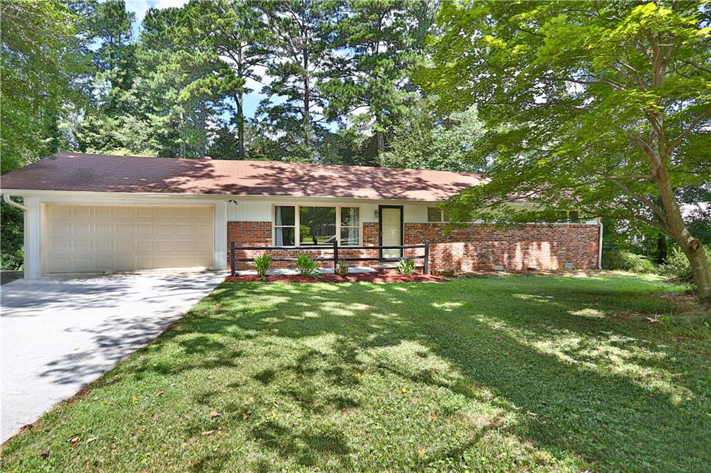 Updated, four-sided brick home in the charming, well established Forest Hills neighborhood. Upon entry you are greeted by gleaming hardwood floors spanning throughout. The oversized living room offers endless possibilities for functionality and accented by a massive picture window. Entertaining is made easy with the well-appointed kitchen featuring granite counters and custom tile backsplash that extends to the open concept dining area and down to the sunken living room which is punctuated by the brick fireplace. Both the guest and primary baths have been beautifully updated with extensive tile work and attention to detail. Freshly painted exterior trim and deck, new plumbing throughout and updated electrical. This quaint community has voluntary access to Forest Hills clubhouse and pool. Conveniently located near shopping, highways and everything that thriving downtown Lawrenceville has to Offer.