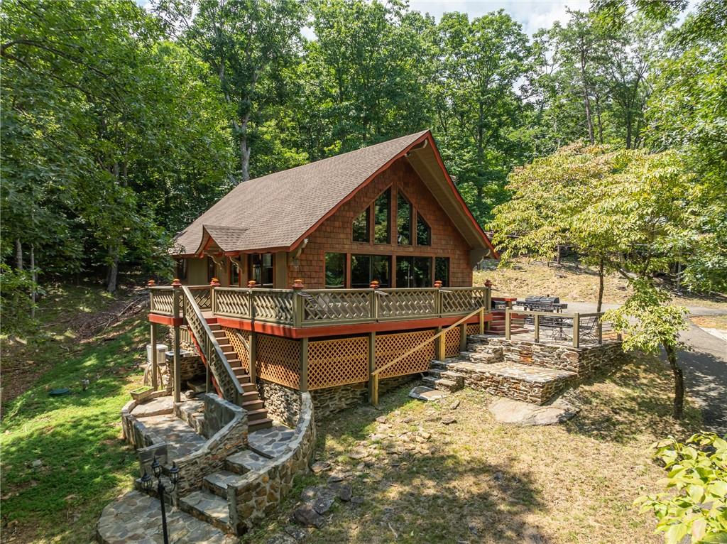 Welcome home to 771 Little Hendricks Mountain Rd! Up the paved driveway, you will feel invited to unwind and enjoy the serene surroundings and might even get a chance to meet Goldilocks and the three bears! This home is a quaint wooden shingled rustic style Chalet, located within the sought after community of Bent Tree. Home is adorned with stacked stone and flagstone paved walkways. Enjoy the fresh mountain air and long weekends in the hot tub, or on several stone paved outdoor seating areas wrap around porch a including a screened-in porch, and a wrap-around porch. Here you will be nestled in a private lot with mountain views, just over an acre with lots of room for entertainment or just listening to the birds.
Cuddle up to a cozy fire on a crisp autumn night outside with the firepit or inside snuggled in front of the floor to ceiling stacked stone, wood burning fireplace. As you step inside you are greeted by the floor to ceiling windows and sliding doors allowing lots of natural light. Enjoy the open concept style of living, dining and kitchen space. The kitchen is fully functionable with lots of cabinets for dishes and extra appliances. Stainless steel appliances, granite countertops, and a gas stove.
You will find warm, hardwood flooring throughout. Vaulted ceilings with exposed beams and upper wooden panels enhance a spacious feel to this charming abode. Other upgraded features are beautiful ship lap ceilings in some of the bedrooms and wooden barn-doors.
The 3-bedroom, 2 full bath home is ready to move into as a full-time residence or can be used as a short-term rental, long term rental or a weekend vacation home. Two bedrooms are on the main floor with an additional bedroom upstairs. Both bathrooms are updated including a large, tiled shower and upstairs you have a Clawfoot soaking tub!
Recent home improvements are a newly replaced roof and a completely new septic system.
Outdoor enthusiasts and active individuals will love the gated golf cart community. Bent Tree boasts a plethora of resort style amenities including the 110 Acre Lake for Swimming, Fishing, Kayaking, and Boating. The Joe Lee Designed 18 Hole Golf Course and clubhouse and restaurant, 2 swimming pools, an Equestrian center with trail rides, hiking trails, indoor and outdoor tennis and pickleball courts, and of course a dog park for your furry companions. Bent tree even has a private Fire Department. You will also have access to some of the best health care from several nearby hospitals, be able to enjoy local Wineries, Breweries, Restaurants and shopping.
A mandatory $2,500 capital contribution fee paid by purchaser to Bent Tree will be due at closing.