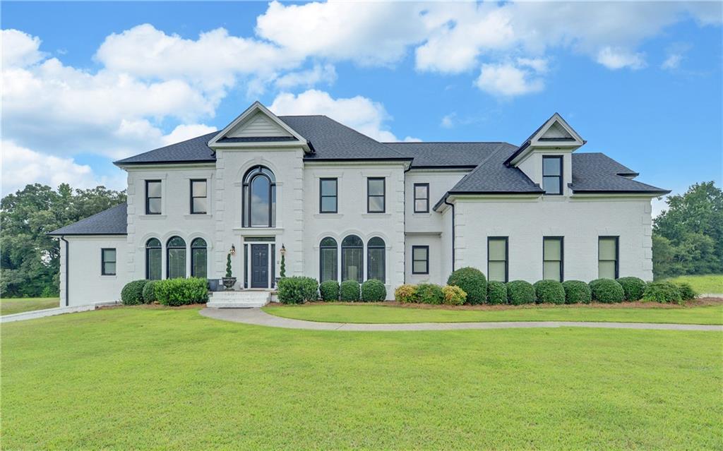 Don’t miss this rare opportunity to own a stunning Georgian masterpiece, perfectly blending country charm with city convenience, nestled on 5.14 acres of gently rolling, lush green landscape that exudes serene country charm while remaining centrally located in Buford. This property feels like a serene countryside retreat while being just moments from I-85, conveniently located between Mall of Georgia and Hamilton Mill. The meticulously maintained 5,716 ft2 home features a freshly painted brick exterior, enhancing its timeless elegance. Step inside to soaring ceilings and an open, airy layout with two staircases for seamless access to the main-level laundry. Also, on the main is the master suite offering direct access to a private, Grecian-style oasis featuring a lighted, heated saltwater pool and expansive spa—your personal paradise for relaxation. Nothing has been overlooked. This home boasts four additional oversized bedrooms, each with its own ensuite, plus a versatile living room/office that could serve as a sixth bedroom or second master suite. The gourmet chef’s kitchen is a showstopper, equipped with a Sub-Zero refrigerator and perfect for hosting elegant gatherings. Additional features include upgraded flooring, all new pool equipment, new windows and garage doors for enhanced efficiency and curb appeal. Auto enthusiasts will appreciate the extra-wide, extra-deep garage, designed to house classic vehicles. The unfinished basement, with high ceilings and pre-installed plumbing, wiring, and ductwork, is ready for your vision—whether it’s a home gym, entertainment hub, or more. Zoned AG-200, this property offers the potential to create a horse farm or a private family compound. This one-of-a-kind property offers unmatched elegance, privacy, and potential. Schedule your private tour today to experience this Southern beauty firsthand!