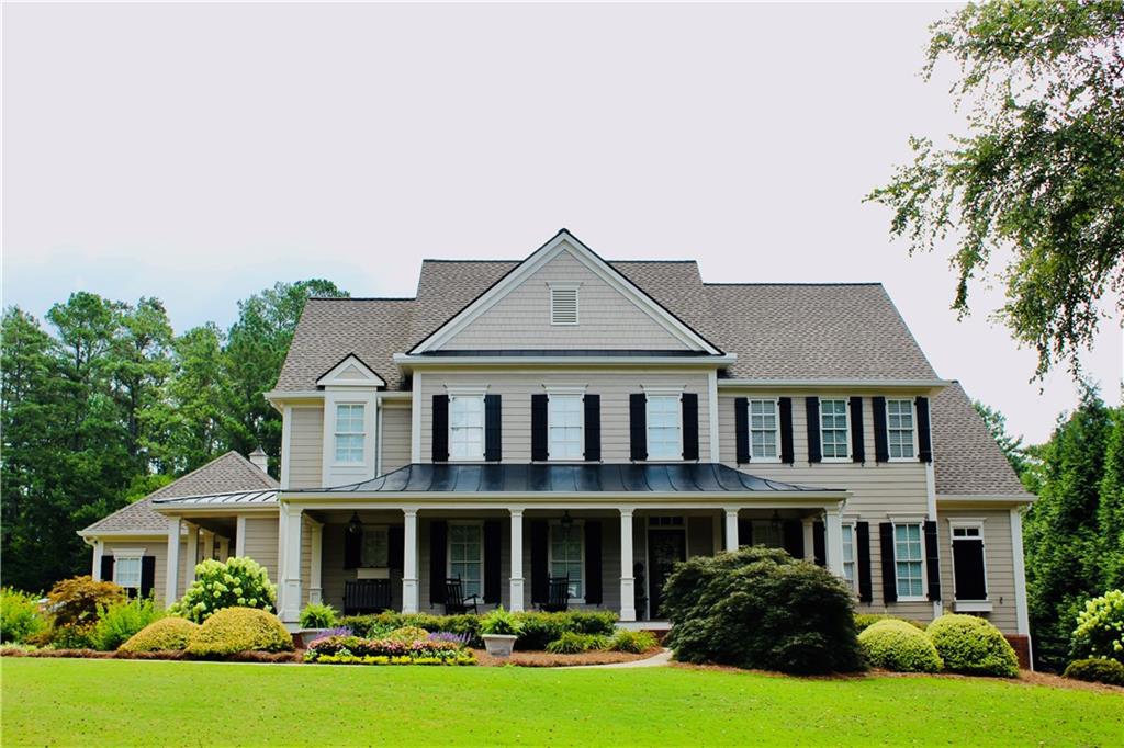 Traditional-style residence featuring a prominent covered front porch with multiple columns