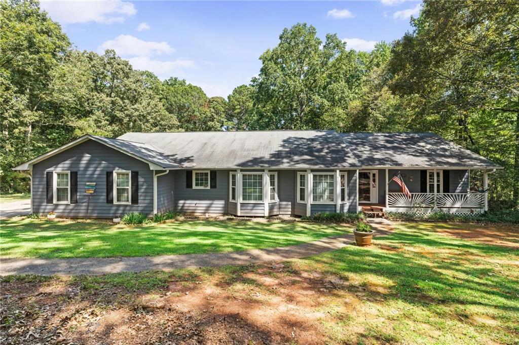 Welcome to this exceptional 5-bedroom, 3-bath ranch with a fully finished basement, nestled on a picturesque 1.8-acre lot in the desirable Briarwood subdivision of Henry County. With no HOA, this property offers freedom and privacy while boasting incredible outdoor living spaces that truly set it apart. From the charming covered front porch to the attached two-car garage, every detail invites you to relax and enjoy. The main level features a screened-in deck with ceiling fans, perfect for year-round enjoyment, while the basement level offers its own screened-in patio overlooking a fully fenced inground pool-an entertainer's dream. Inside, you're welcomed by a bright foyer that flows into a spacious family room with a cozy fireplace and two sets of double doors leading out to the deck. The formal dining room connects seamlessly to the kitchen, which offers abundant cabinetry, a breakfast area, and a nearby laundry room with built-in storage and deck access. The oversized primary suite is located on the main level and features a walk-in closet and an en suite bath with double vanities, a soaking tub, and a separate shower. Two additional bedrooms and a full bathroom complete the main floor. Downstairs, the finished basement provides a versatile living area with a kitchenette, two bedrooms, a full bath, and private access to the patio-perfect for an in-law suite, guest accommodations, or hobby and flex spaces. The home is thoughtfully equipped with two septic systems, one for each level, for added convenience. With its expansive lot, resort-style pool area, and multiple screened living spaces, this home offers a rare combination of comfort, functionality, and Southern charm.