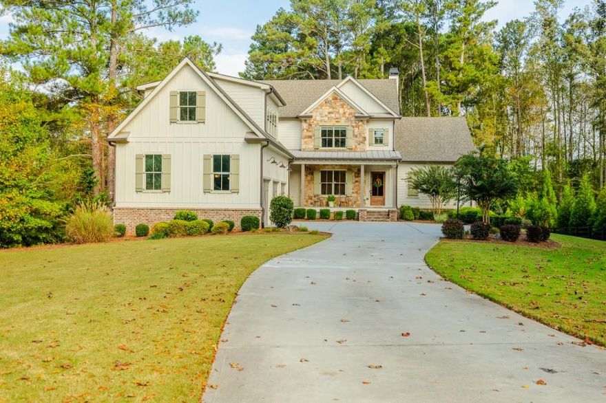 This 5-bedroom, 5.5-bath home offers a perfect balance of elegance and easy living. A welcoming front porch overlooks lush landscaping, setting the tone for the inviting interior where heart pine floors, beamed ceilings, and thoughtful upgrades create an atmosphere of warmth and refinement. The open-concept layout is ideal for both relaxed evenings and lively gatherings-enjoy the fireside family room with custom built-ins, entertain in the formal dining room, or prepare meals in the chef's kitchen with 6-burner gas range, double ovens, built-in microwave, and a generous island with seating. The main-level owner's suite is a serene retreat with vaulted ceilings, spa-like bath, and a custom walk-in closet. A second main-level suite offers flexibility for guests or a private home office. A well-planned mudroom and laundry with smart steamer add convenience to daily life. Upstairs, three additional bedrooms, two full baths, a large bonus/media room, and a finished suite with full bath provide abundant possibilities-au pair suit, hobby room, or a comfortable movie lounge. The unfinished daylight basement opens to a flat backyard-ready for gardening, entertaining, or the addition of a pool. Enjoy peaceful views from the expansive deck or screened porch. Additional features include a 3-car garage with fresh epoxy flooring, whole house generator, smart home technology, irrigation system, and integrated audio. Located minutes from all things Milton (Scottsdale Farms, Matildas Music Under the Pines, 7 Acre Barn & Grille, etc) his home offers both tranquility and convenience-perfect for those who appreciate timeless design, quality finishes, and room to live life their way.
